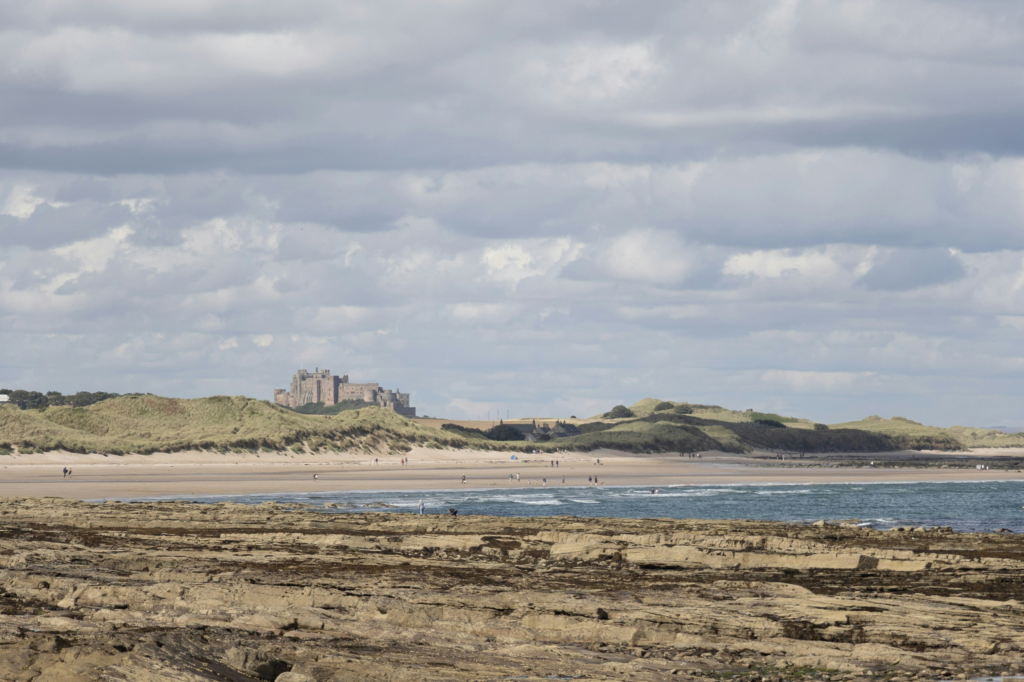 Schloss auf einem Hügel mit Blick auf einen felsigen Strand und den Ozean