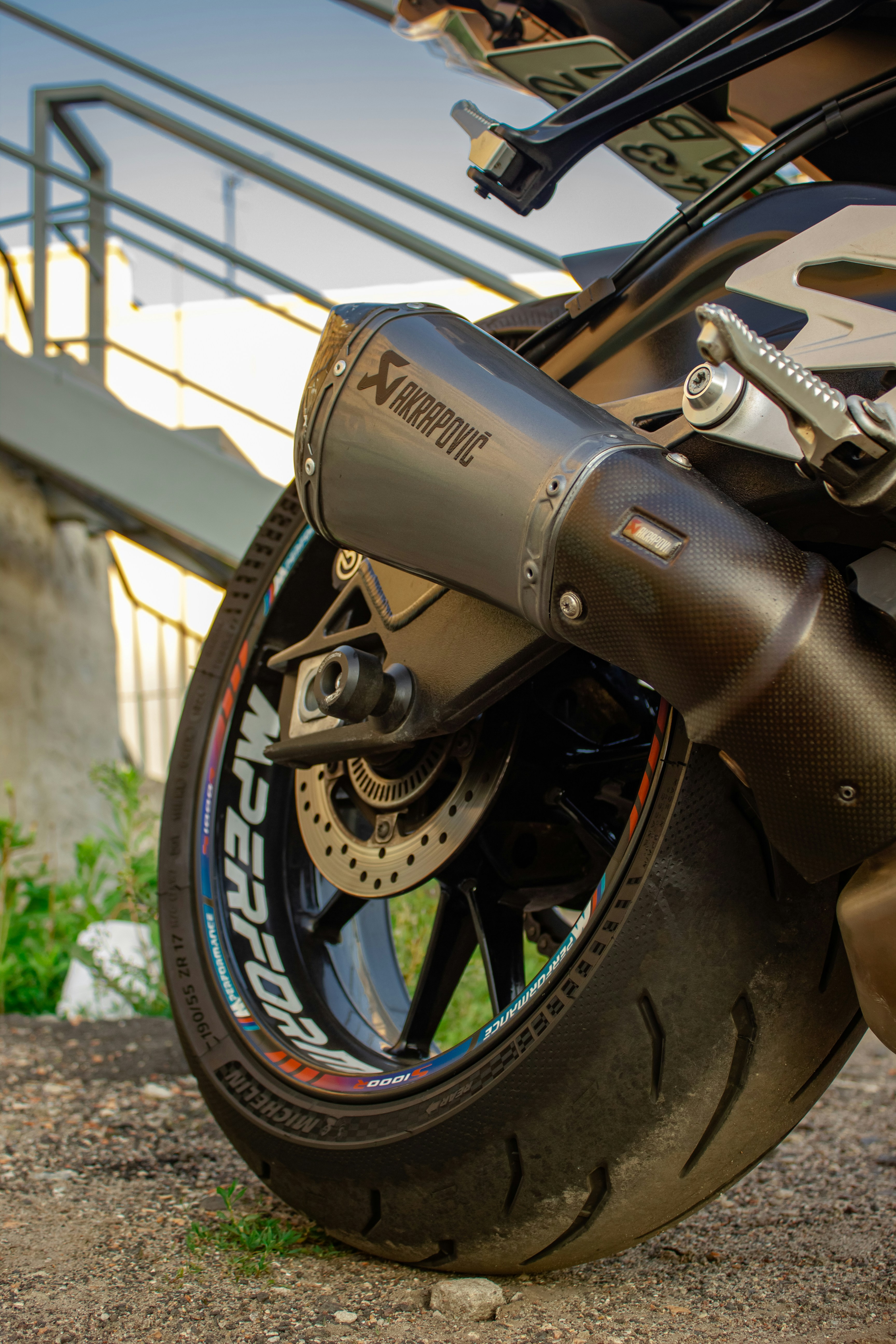 Close up of a motorcycle exhaust and wheel.