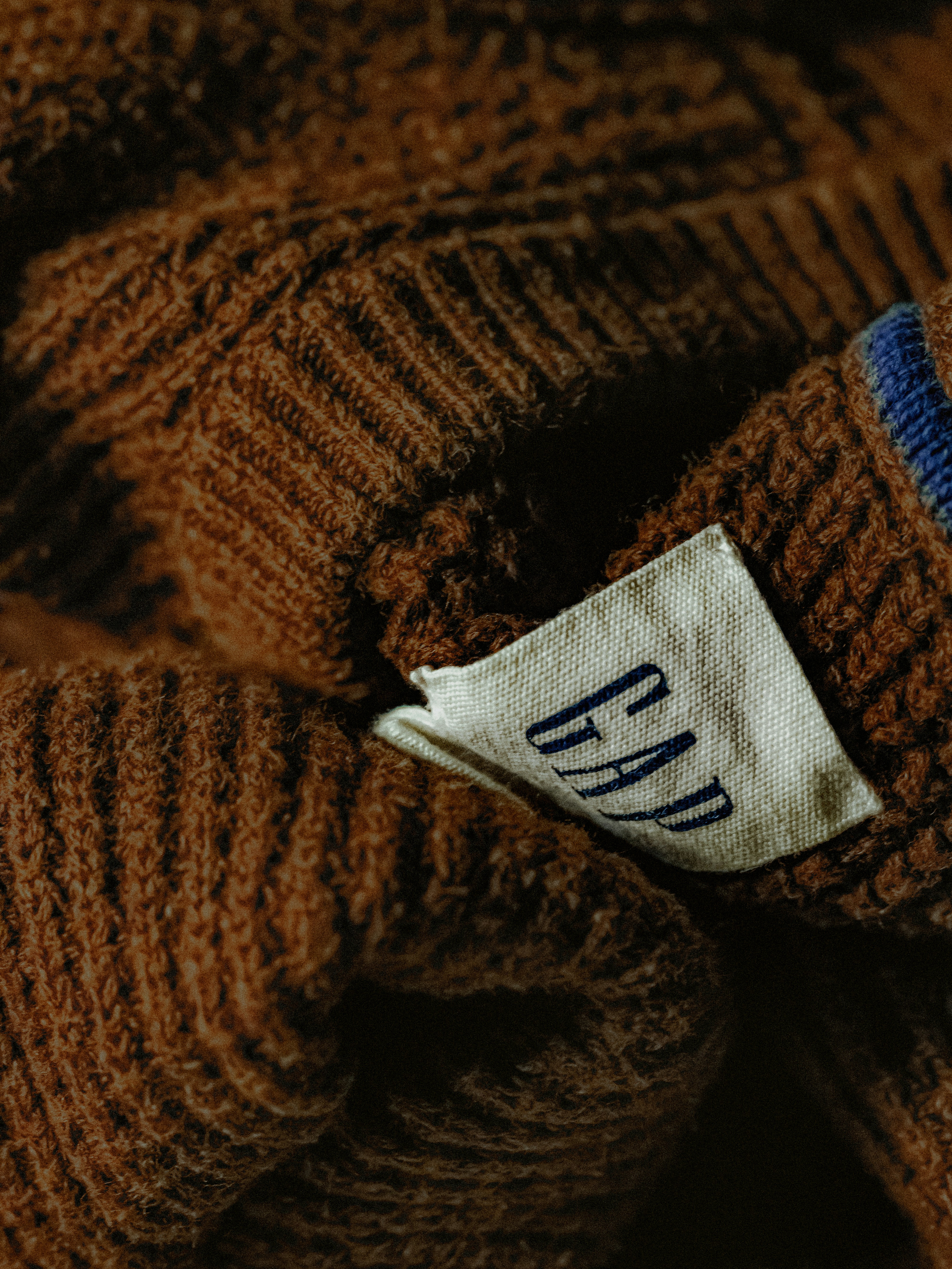 Close-up of a brown knit sweater with a gap label.