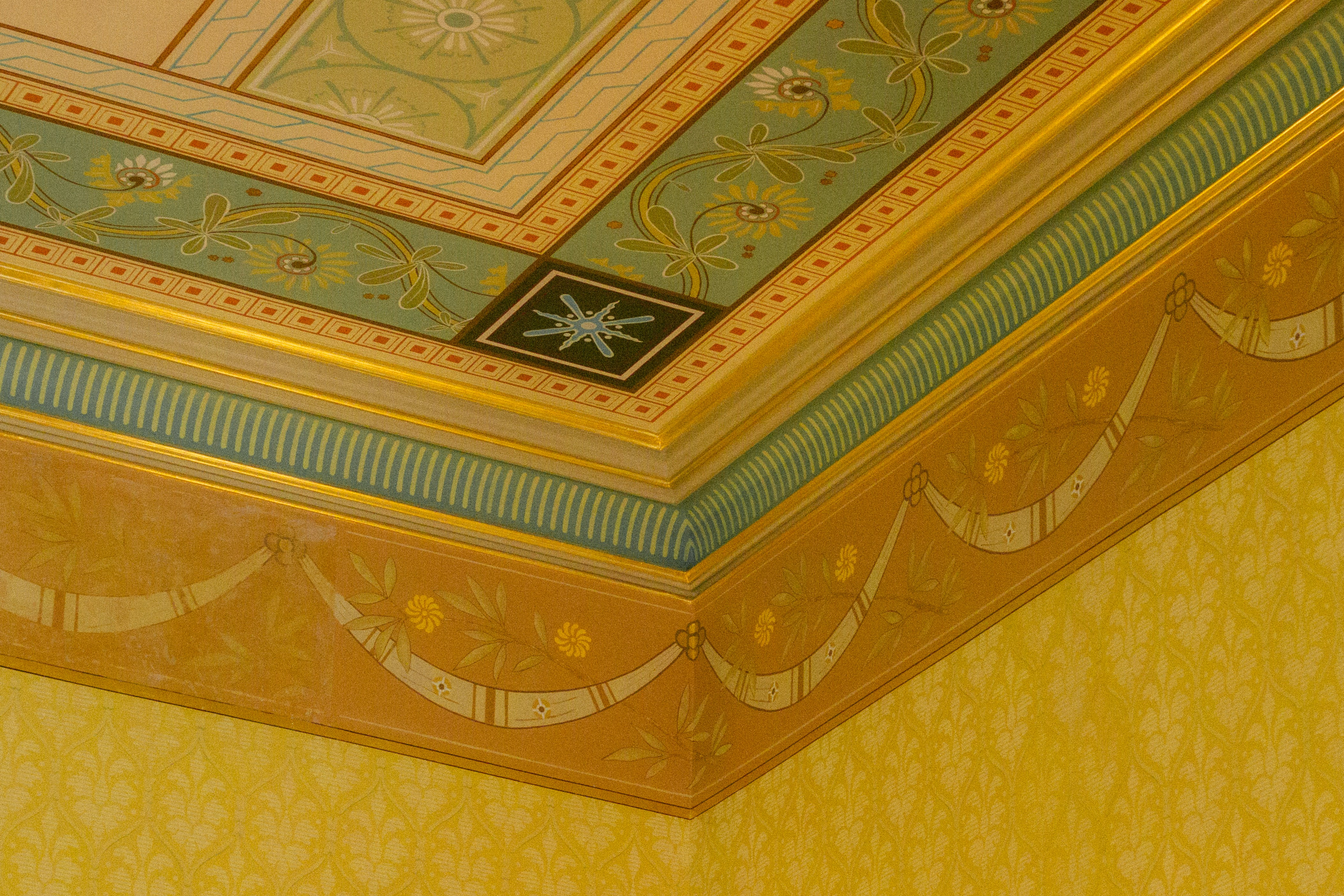 Techo ornamentado con motivos decorativos y molduras doradas