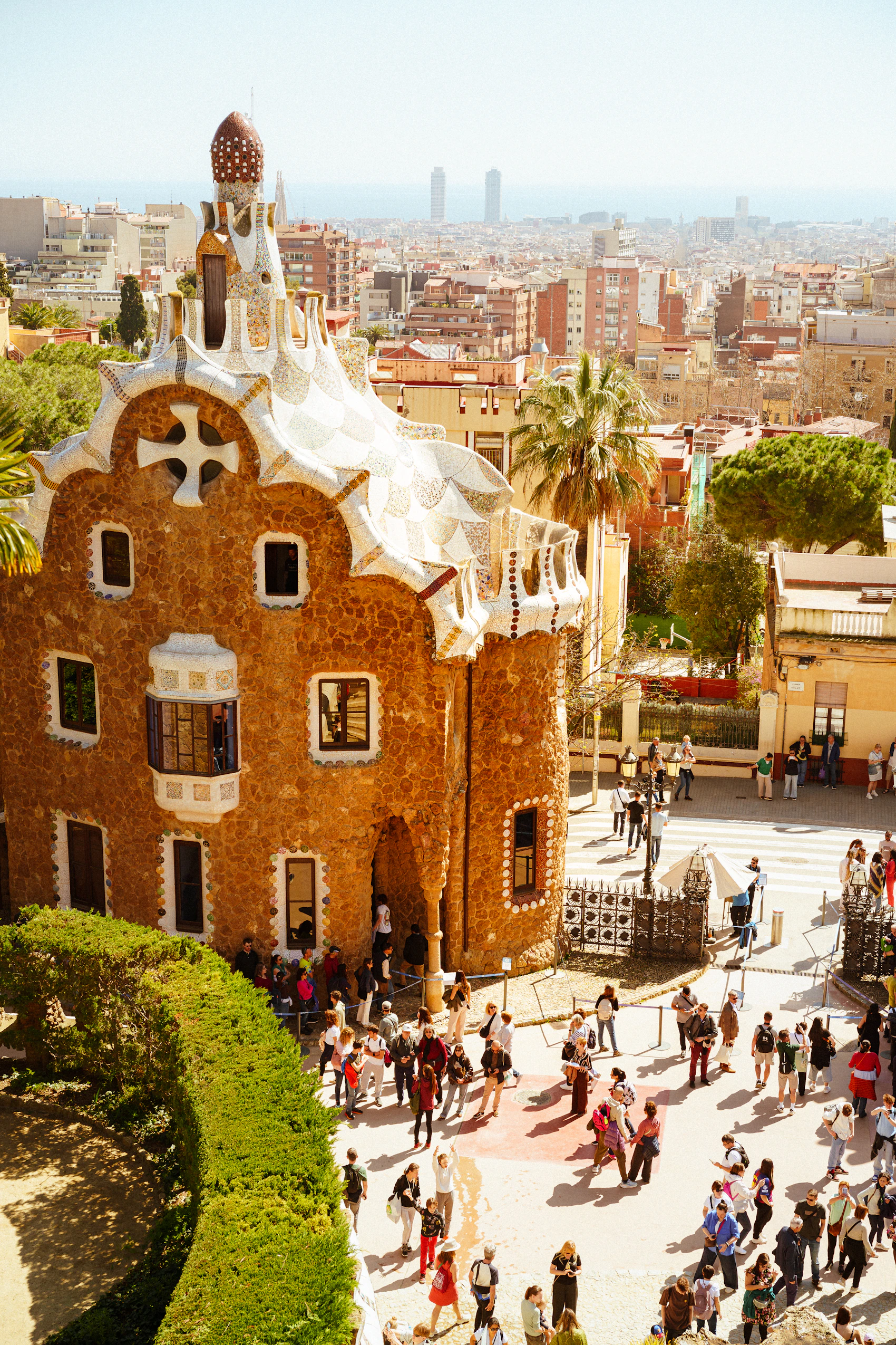 Park Güell terraces, stonework and Barcelona city views beneath a clear sky
