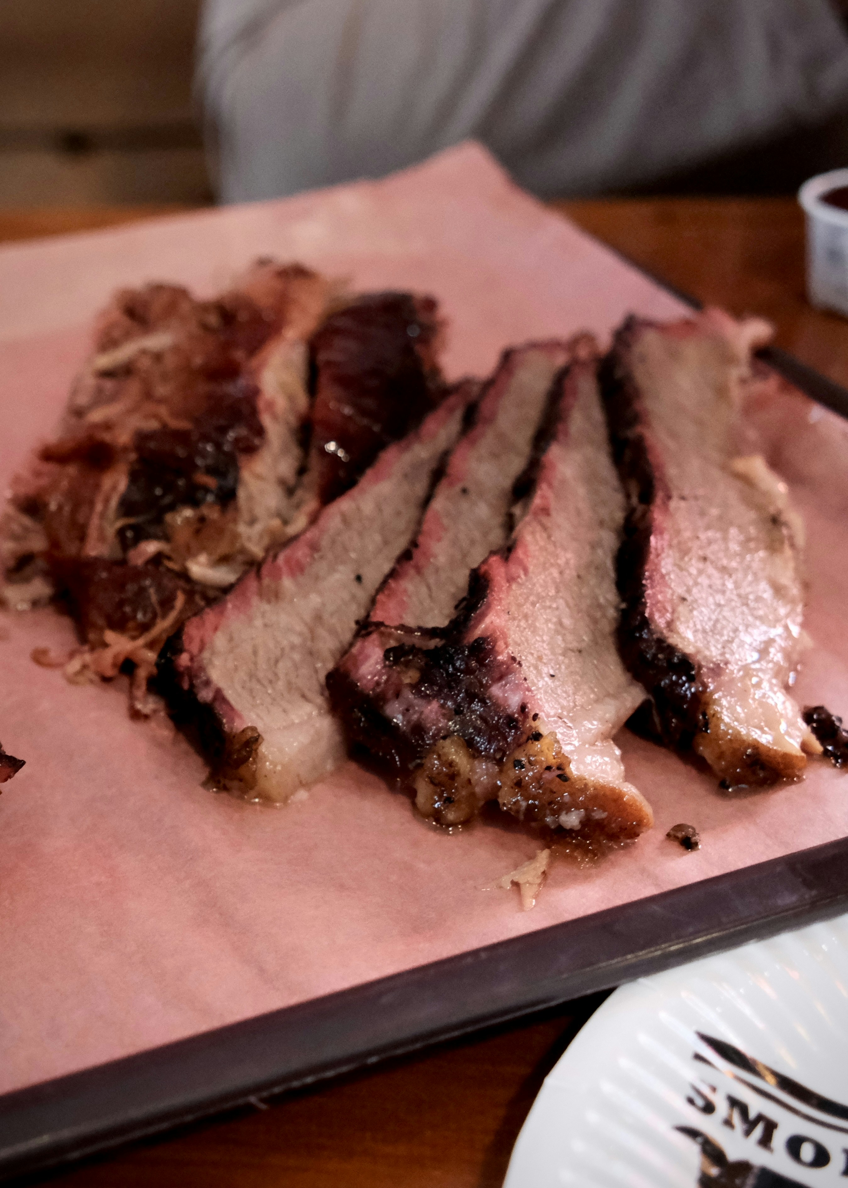 Sliced smoked brisket on pink butcher paper