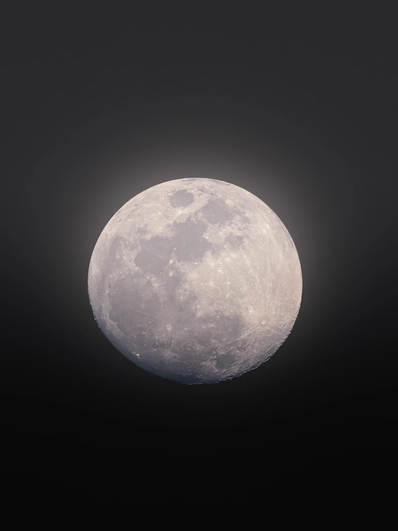 A full moon glowing softly in a dark sky