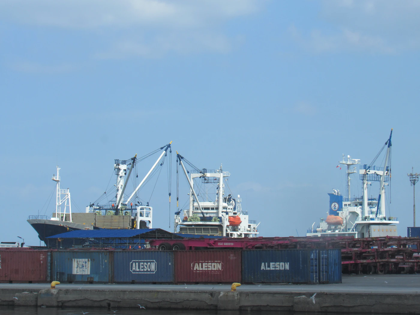 Container port with cargo vessels, freight containers and maritime infrastructure