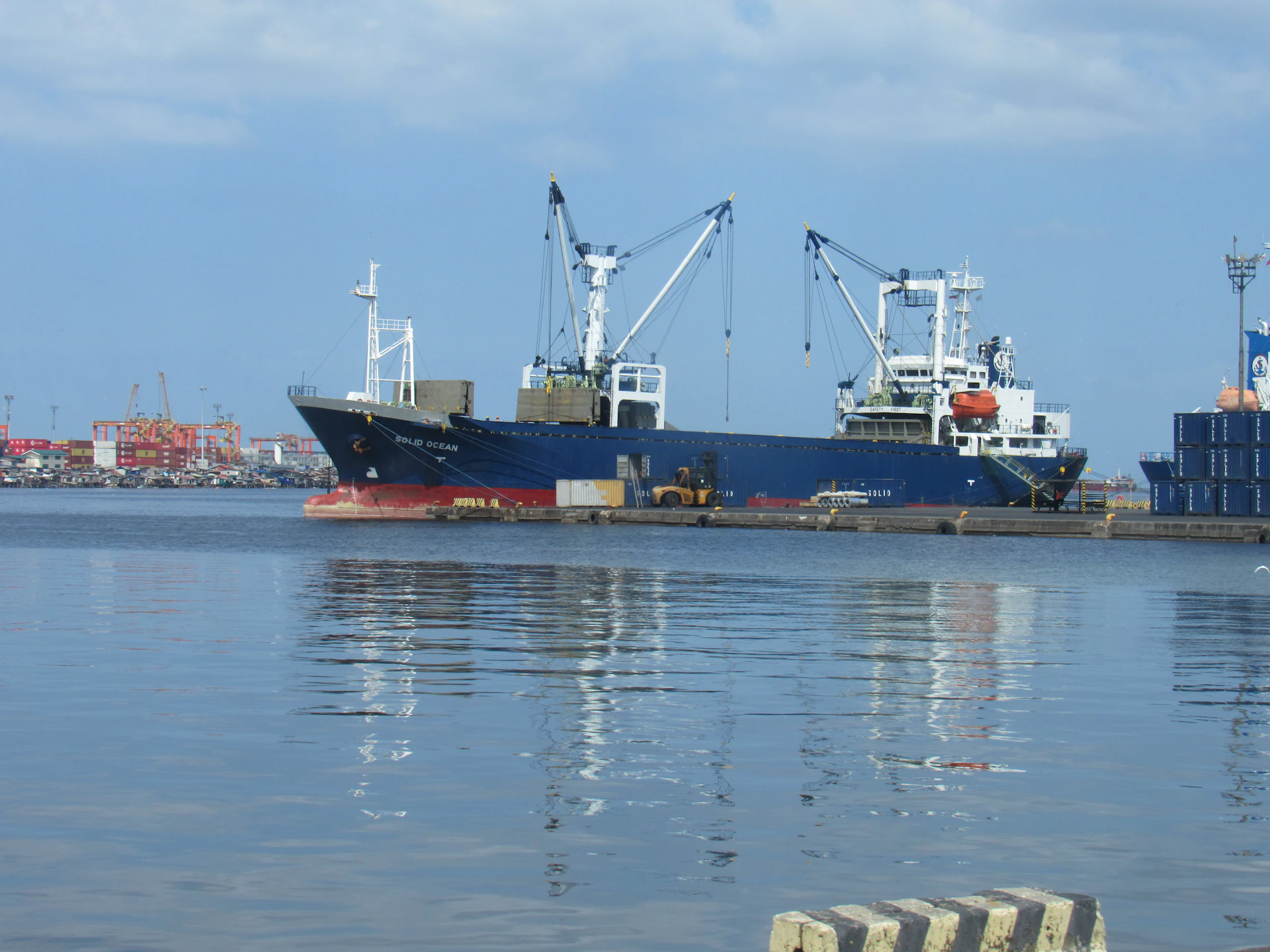 Cargo ship docked at a harbor with cranes