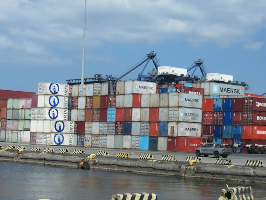 Stacked shipping containers at a busy port terminal