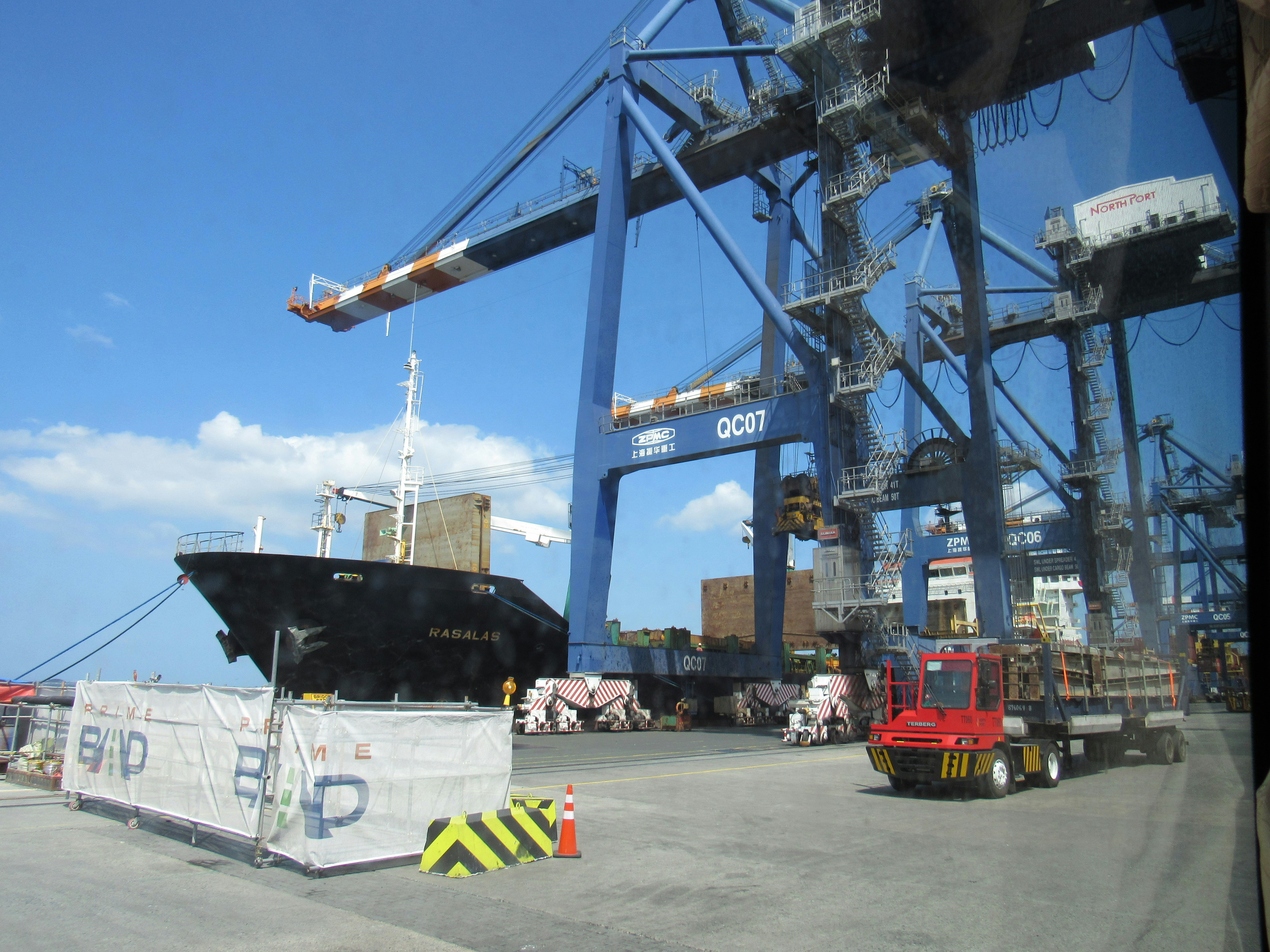 Cargo ship being loaded by large cranes at a port.