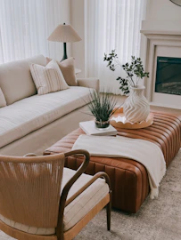 A modern living room with a leather ottoman and sofa.