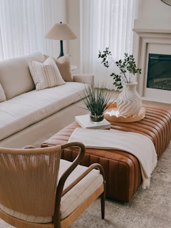 A modern living room with a leather ottoman and sofa.