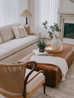 A modern living room with a leather ottoman and sofa.