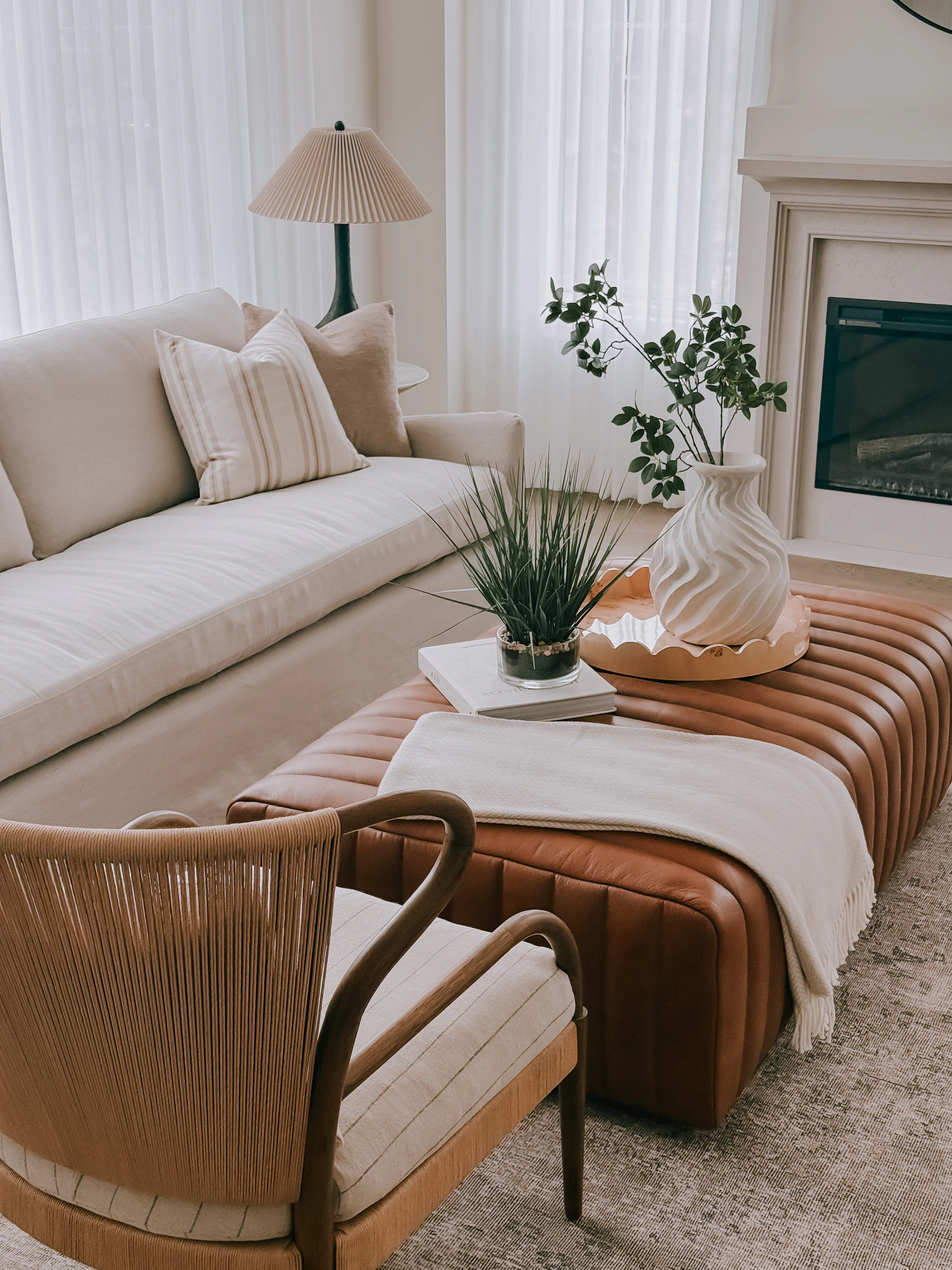 A modern living room with a leather ottoman and sofa