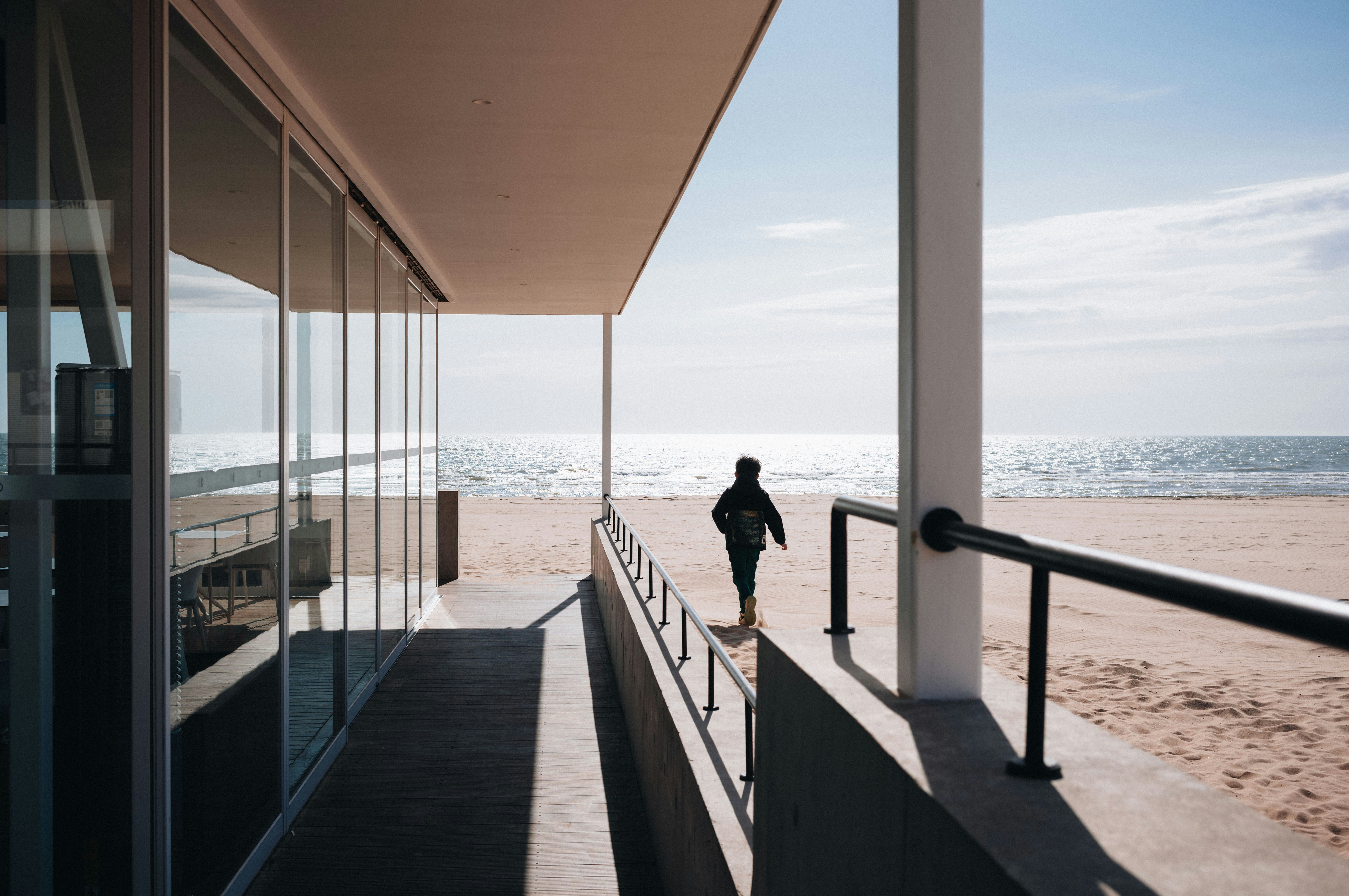 Person walking on ramp towards a beach