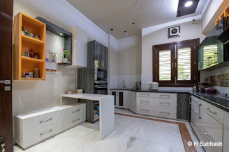 Modern kitchen with white cabinets and orange shelves