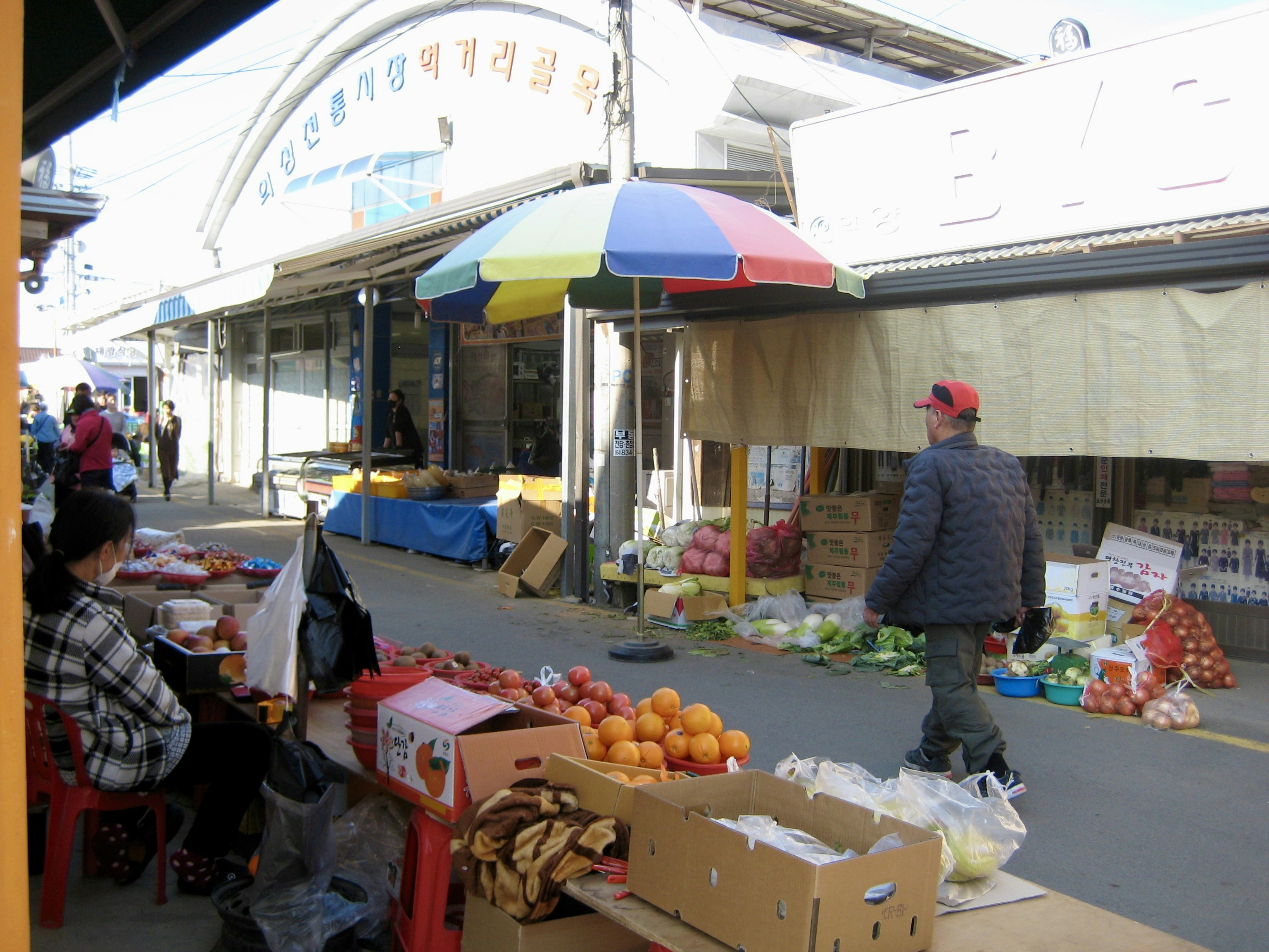 People at an outdoor market with fresh produce.