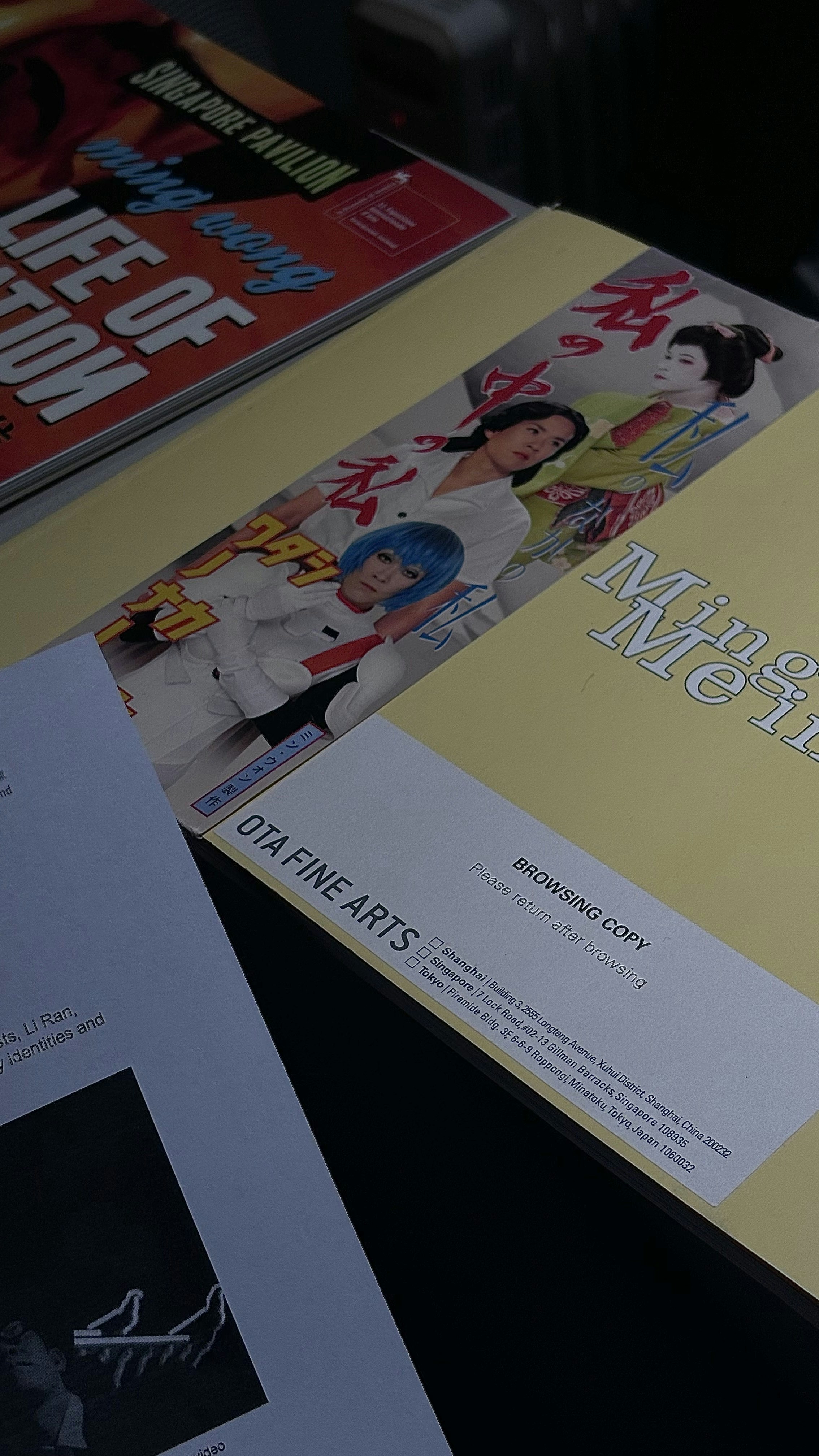 Stack of books and magazines with japanese text.