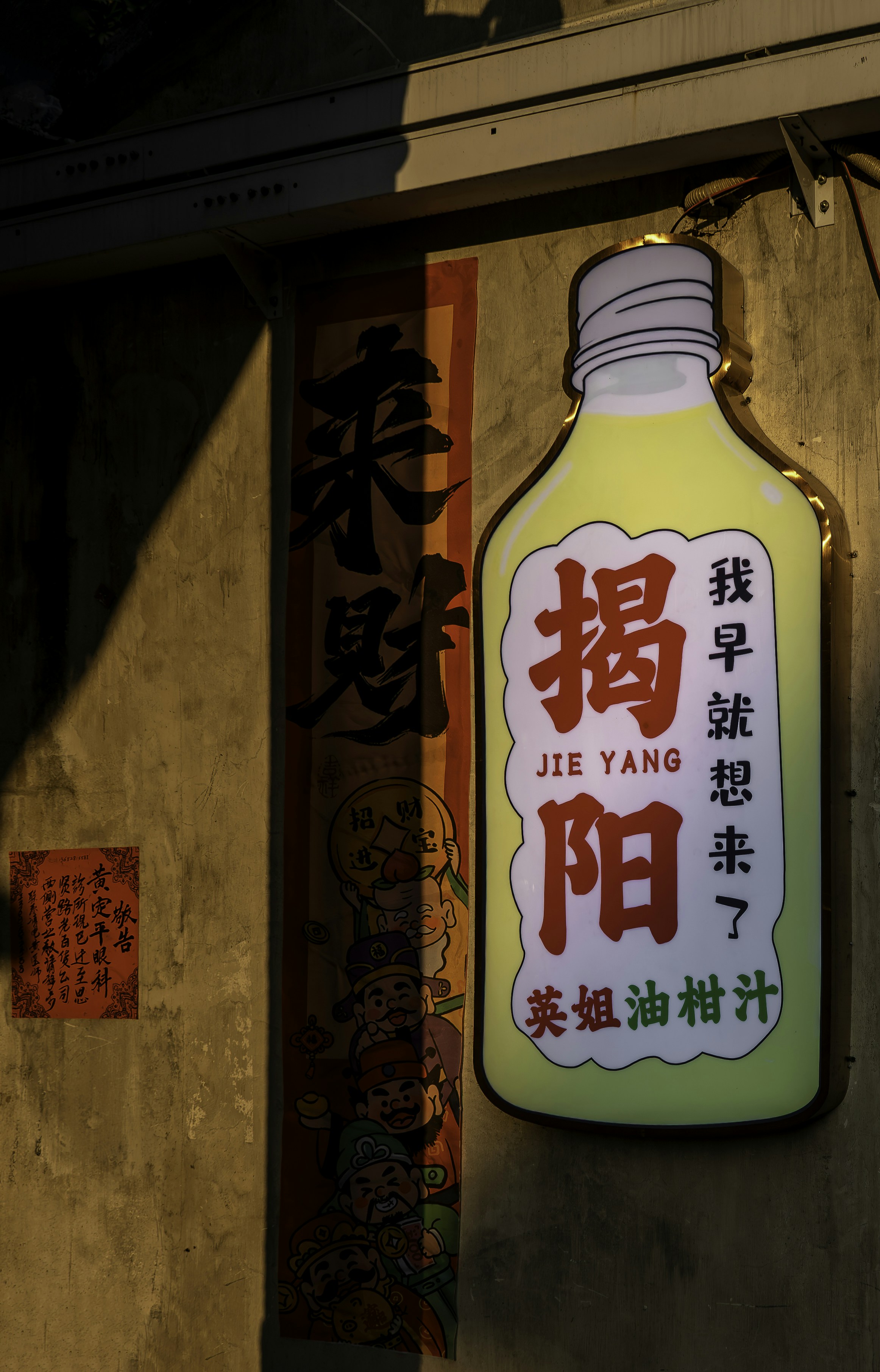 Illuminated bottle-shaped sign with chinese characters.