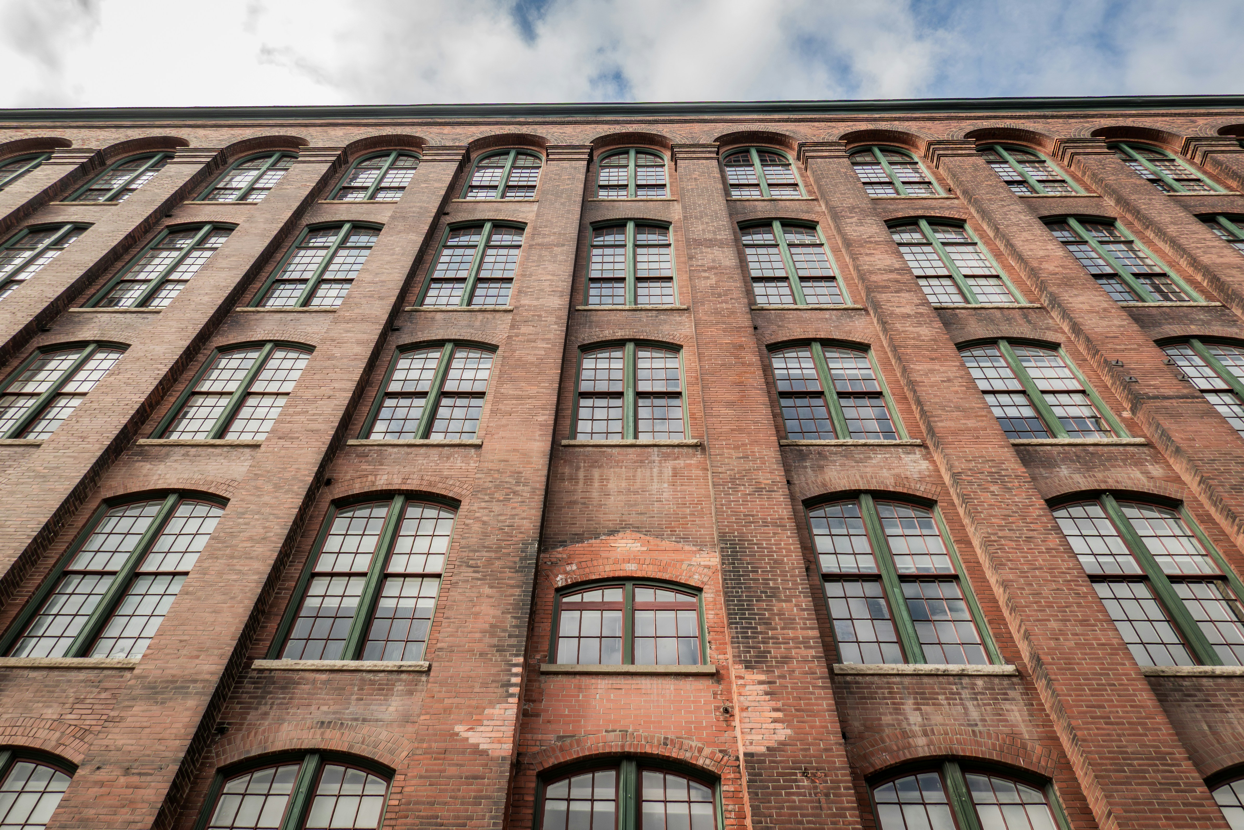 Tall brick building with many windows against sky