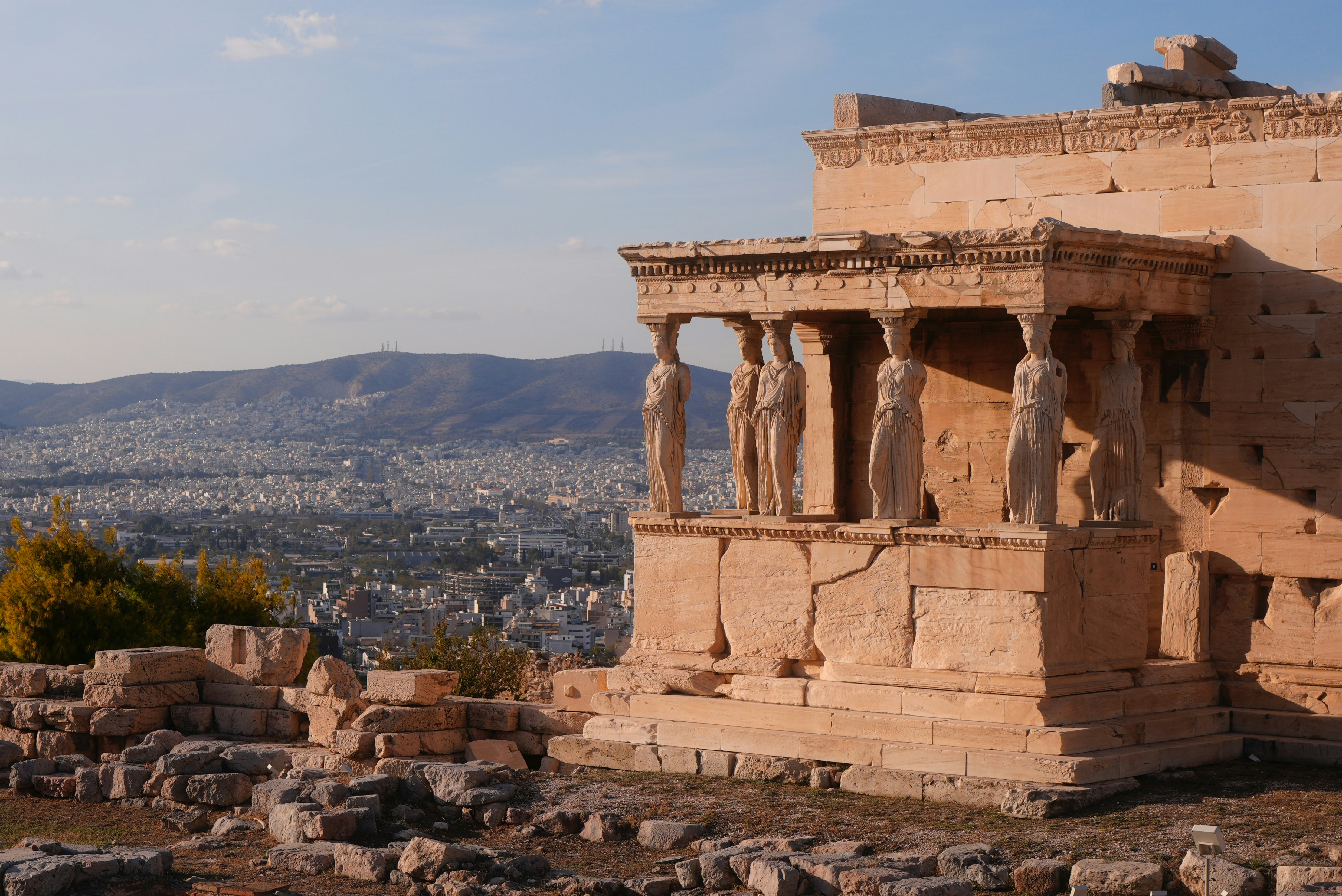 Ancient greek ruins with statues overlooking a city