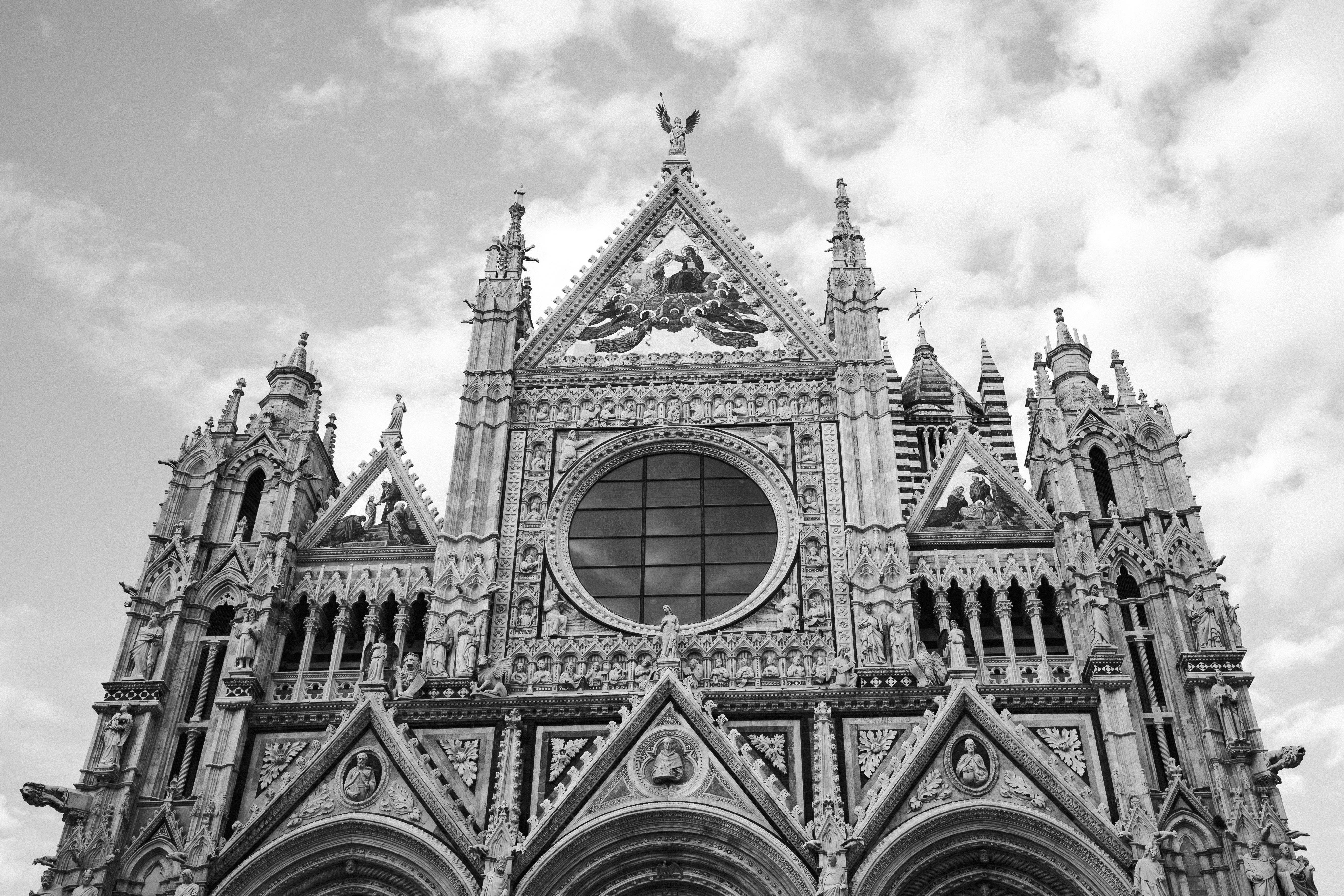 Ornate gothic cathedral facade against a cloudy sky