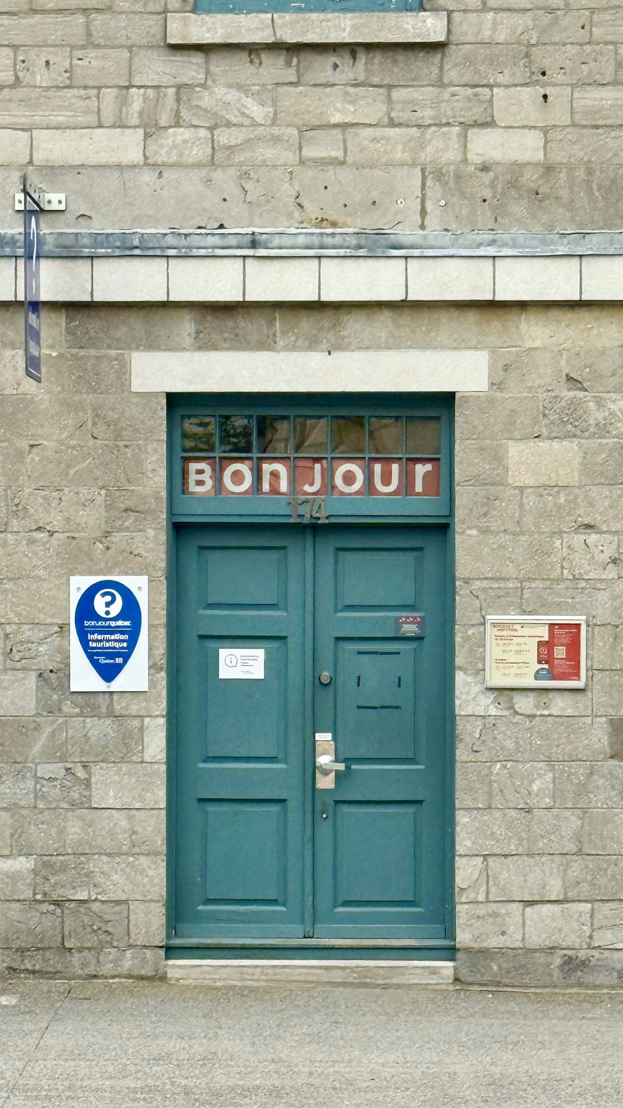 Porte doppie color turchese con il cartello "bonjour" sopra