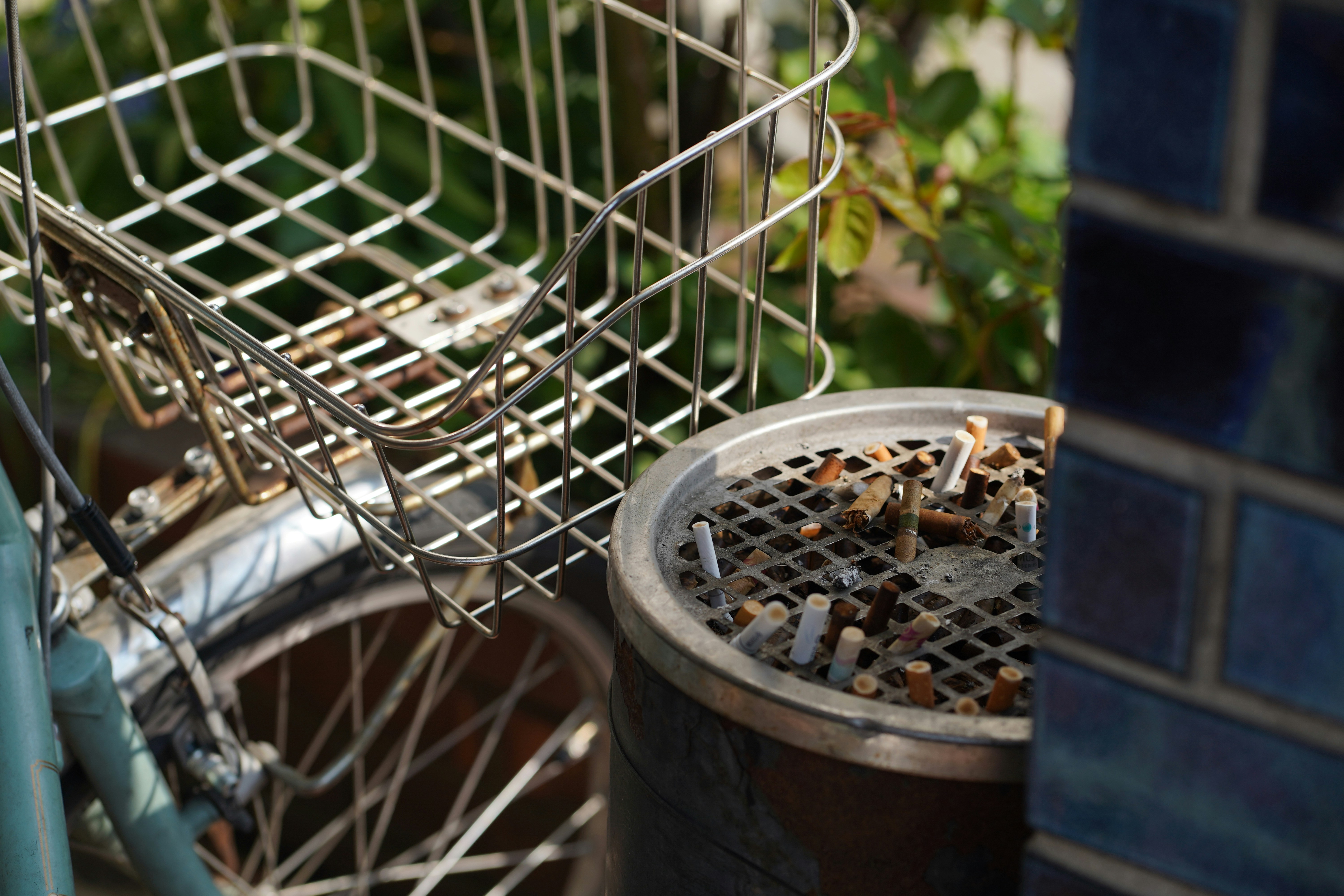Panier de vélo et cendrier débordant avec des mégots de cigarette