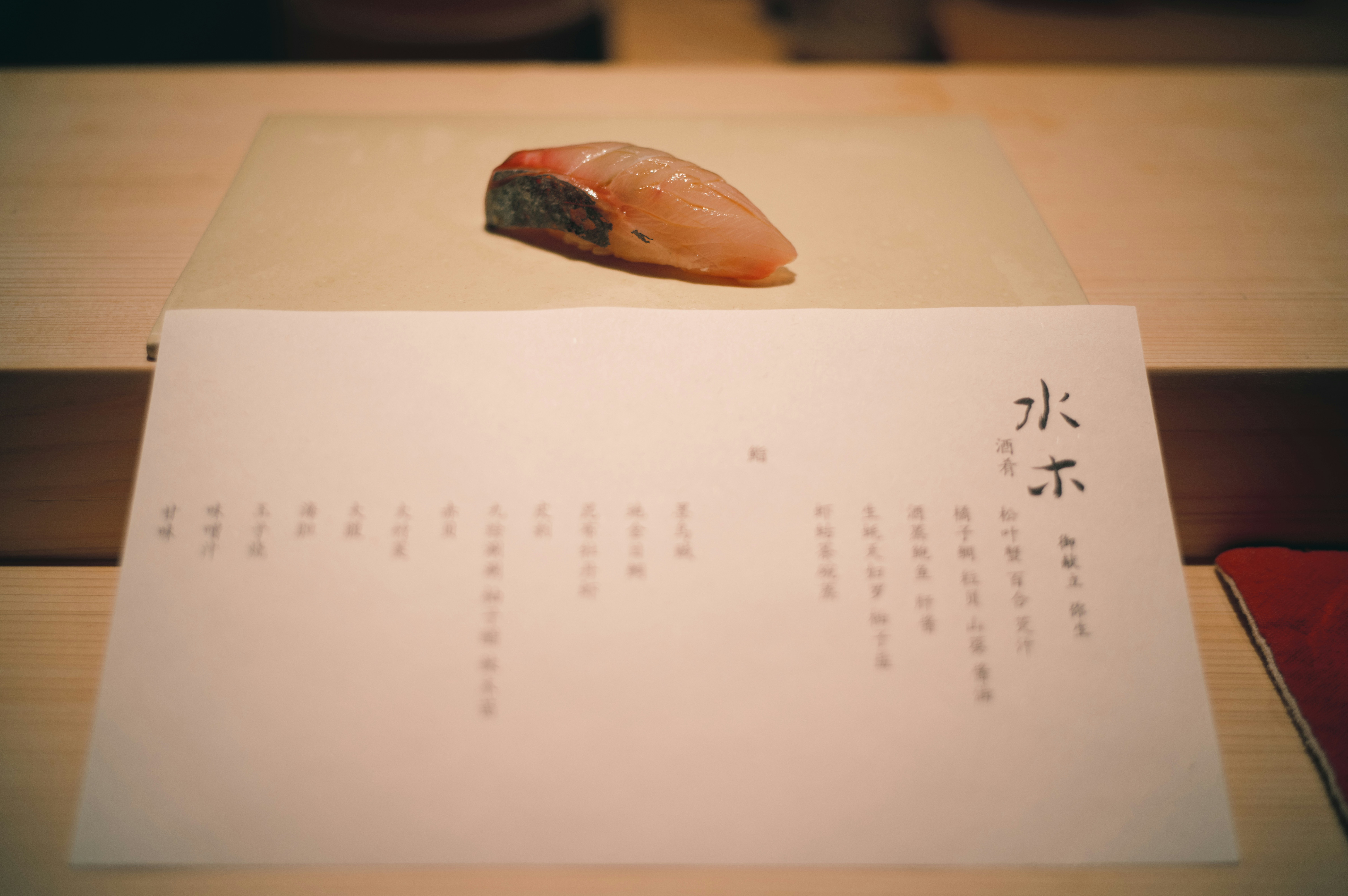 A single piece of sushi on a wooden board.