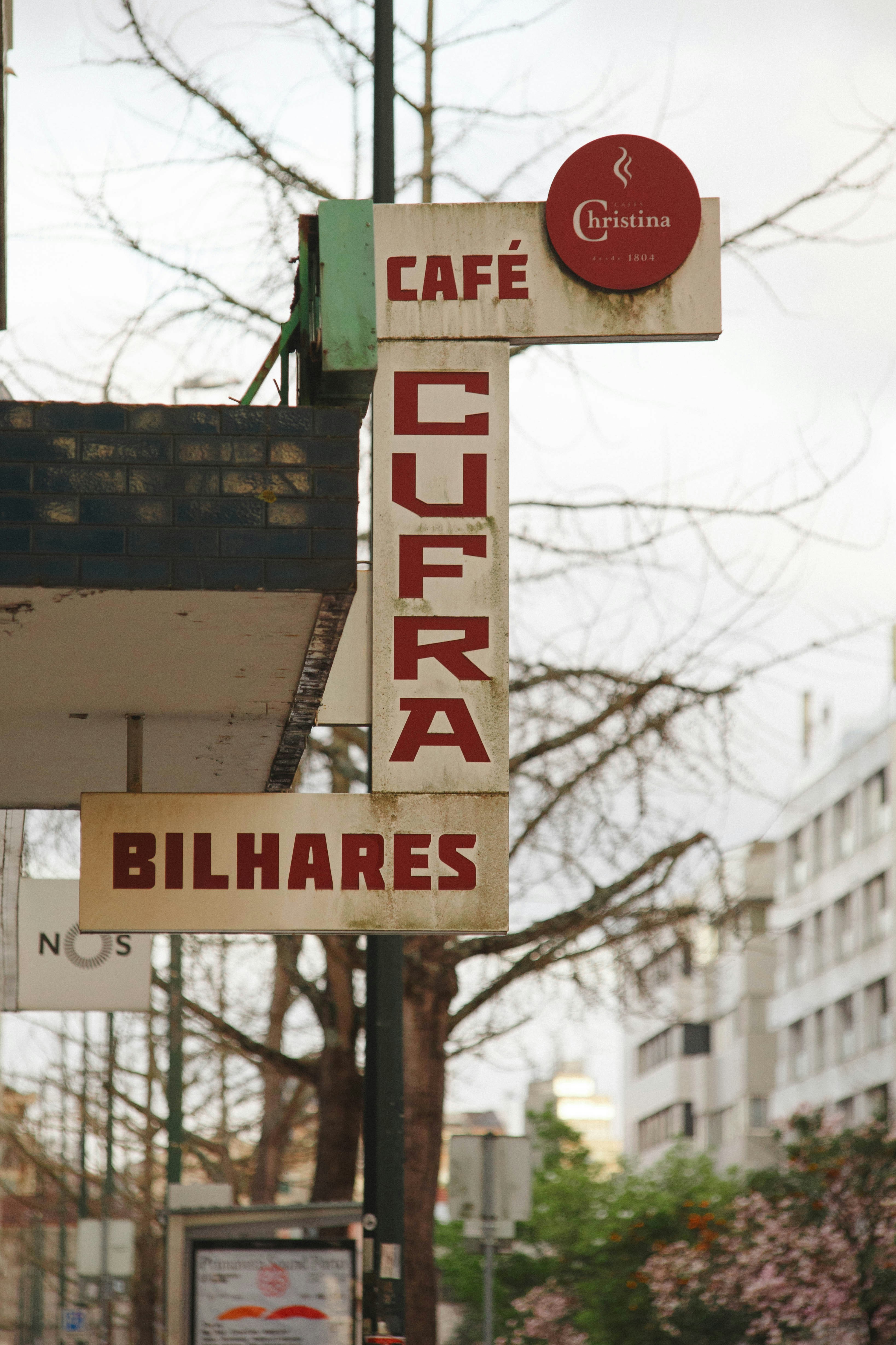 Cartello del Café Cufra Bilhares con alberi e edifici