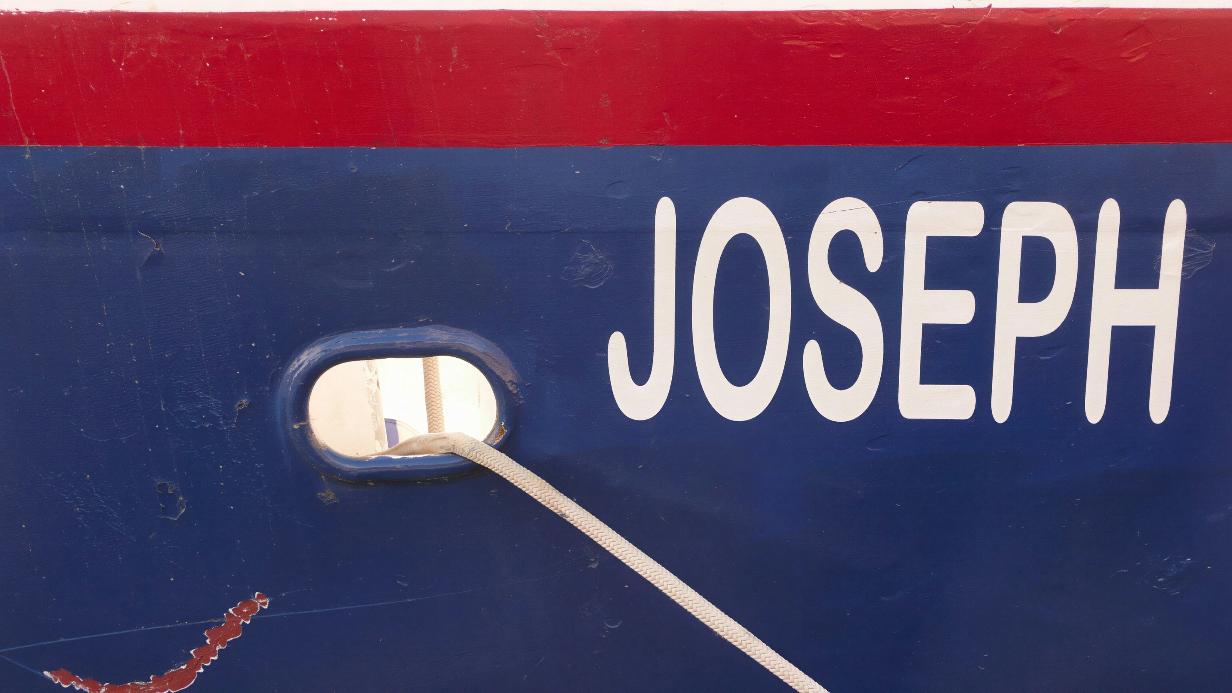 Boat name lettering on transom surface in clear blue letters