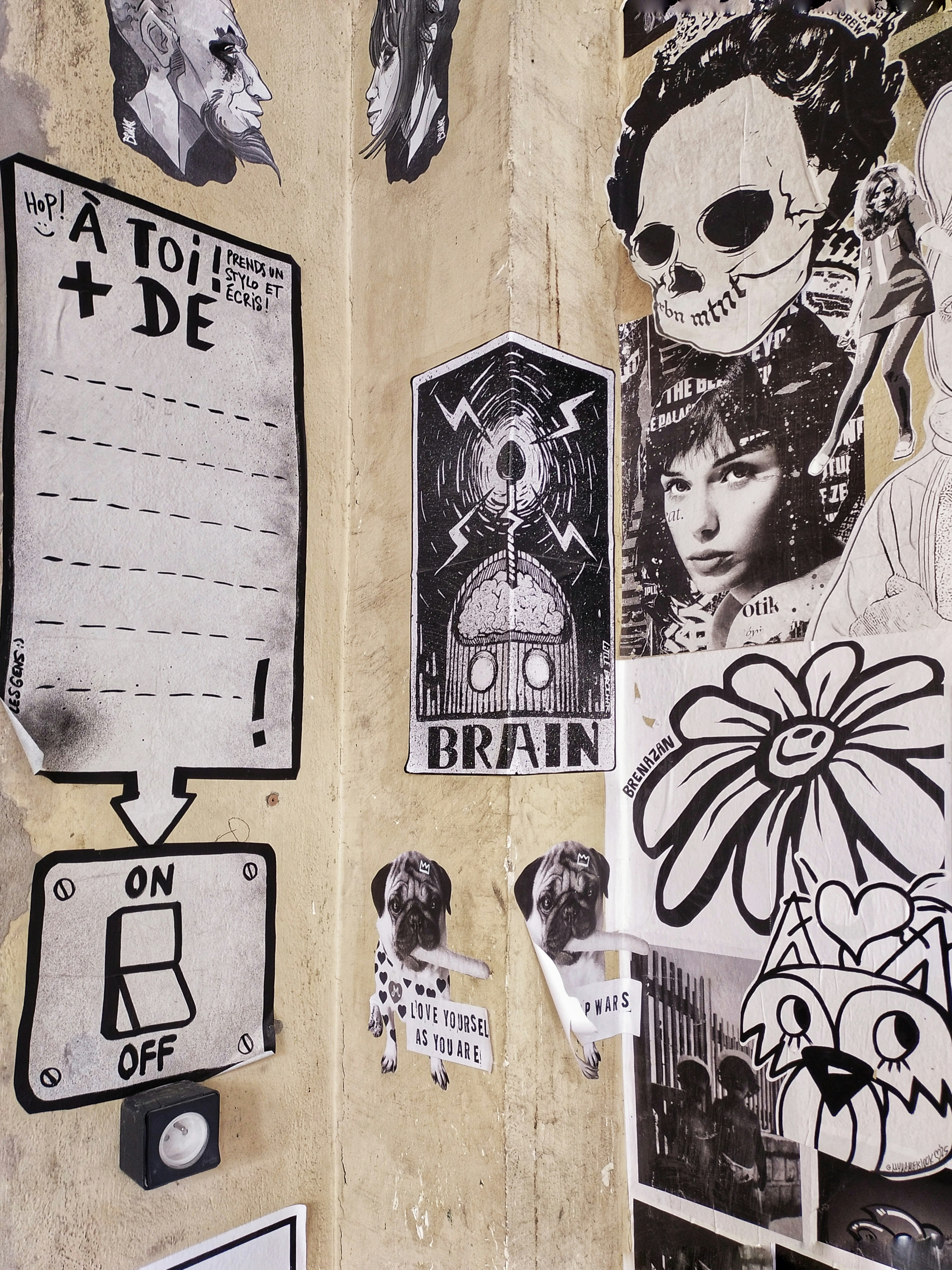 Collage of black and white art and photographs on wall.