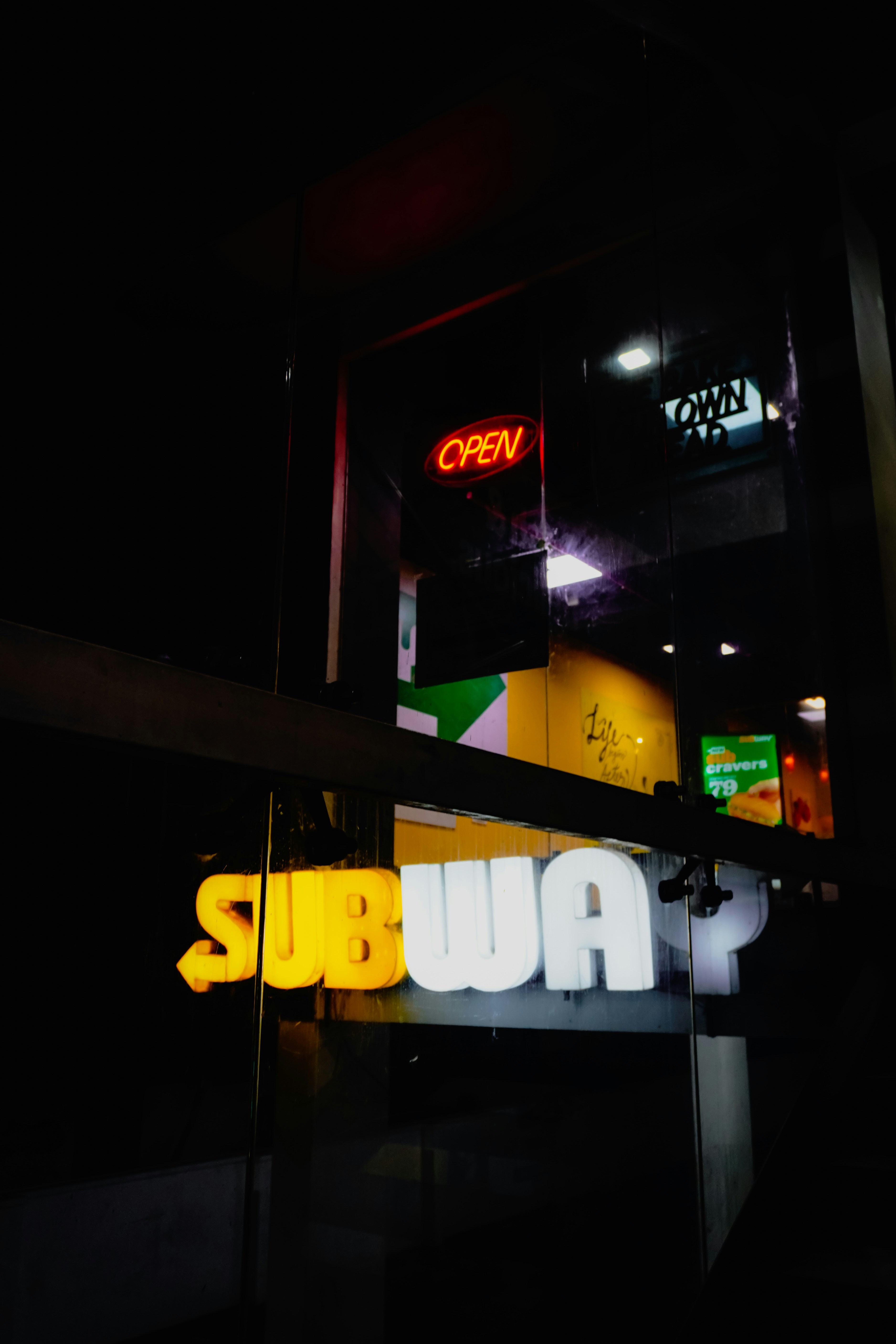Subway restaurant sign at night with open sign
