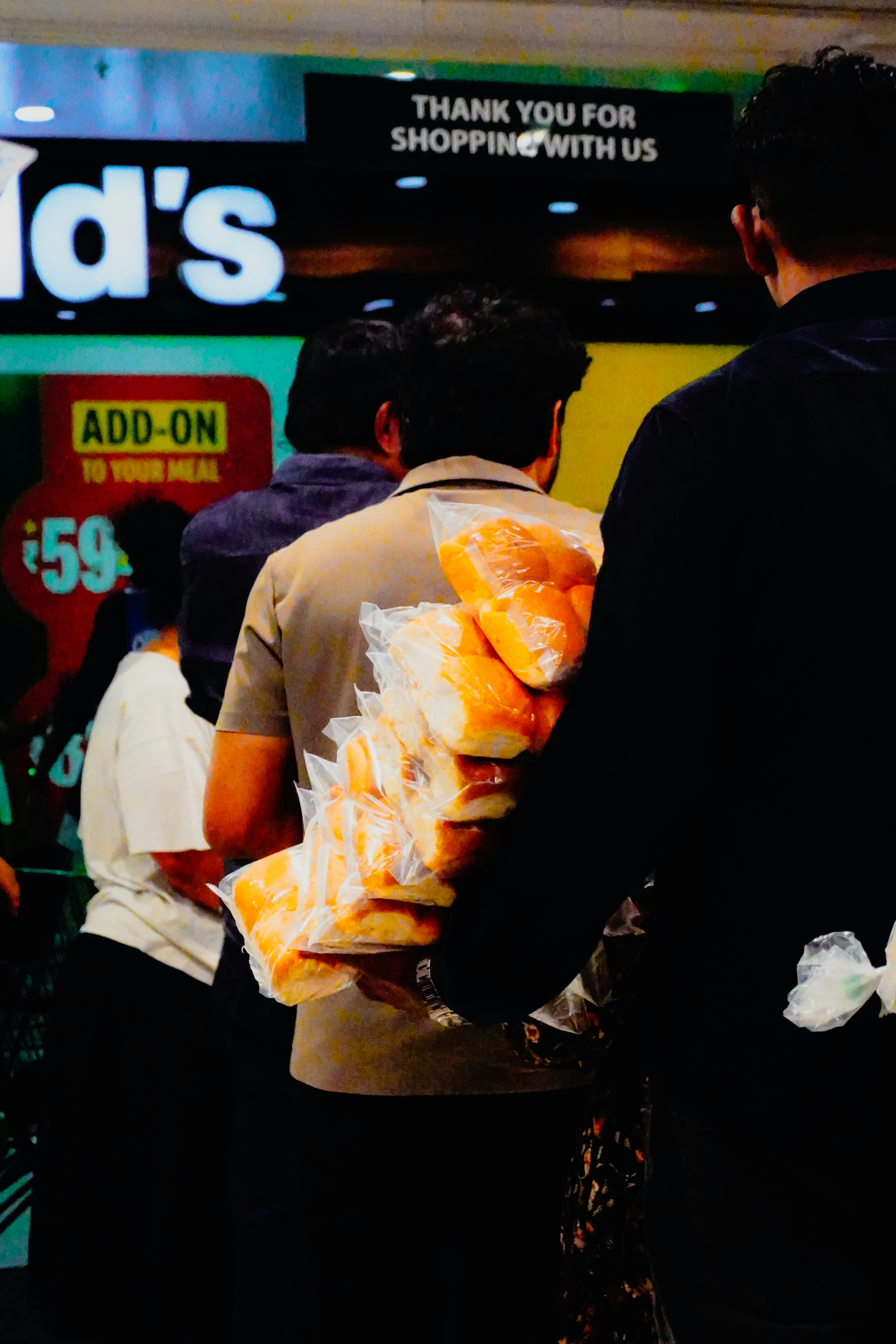 People carrying bags of bread rolls in a store