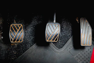 Three car pedals on the floor