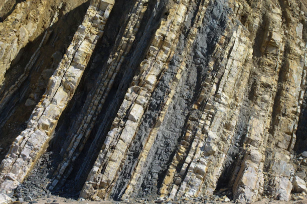Layered rock formations with dark and light strata