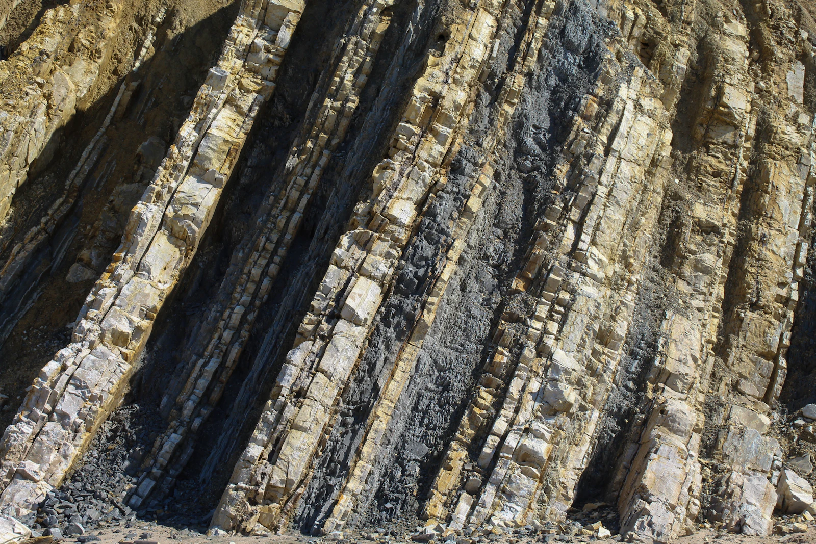 Angled sedimentary rock strata showing distinct layers of light and dark stone, representing the three separate layers researchers found in ChatGPT's retrieval system: a discovery index, a reading cache, and rare live page opens