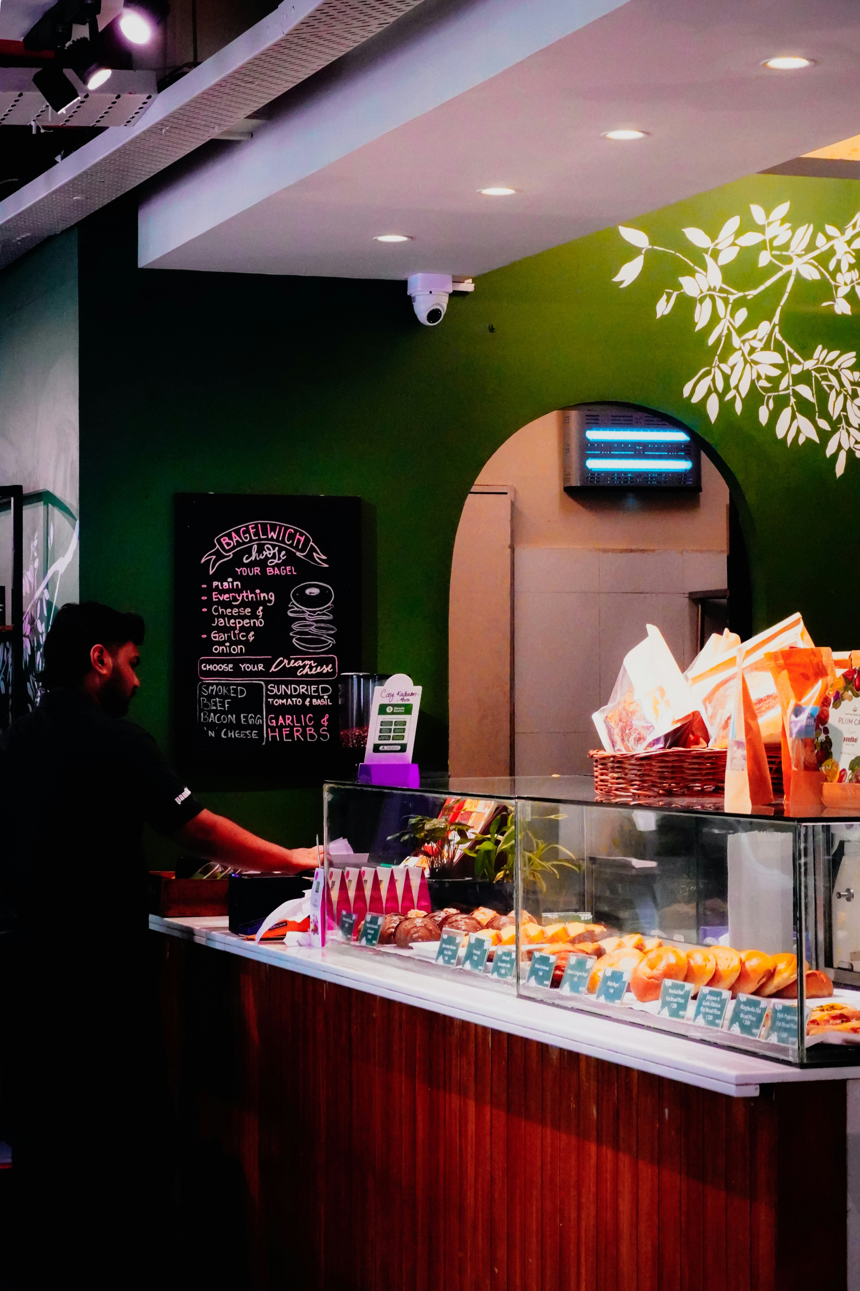 Hombre sirviendo comida en la barra de un café con pasteles