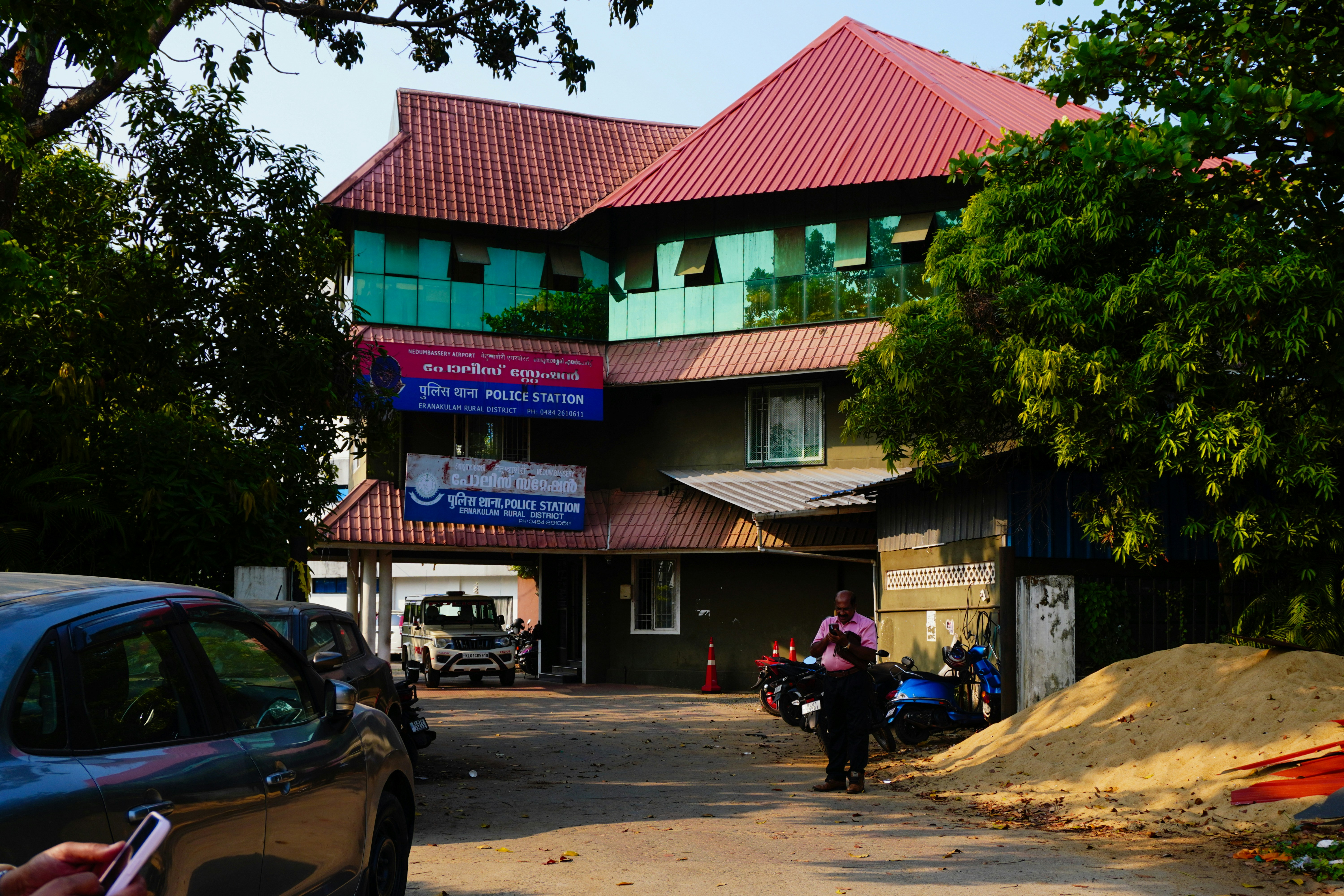 A multi-story building with cars and motorcycles outside.