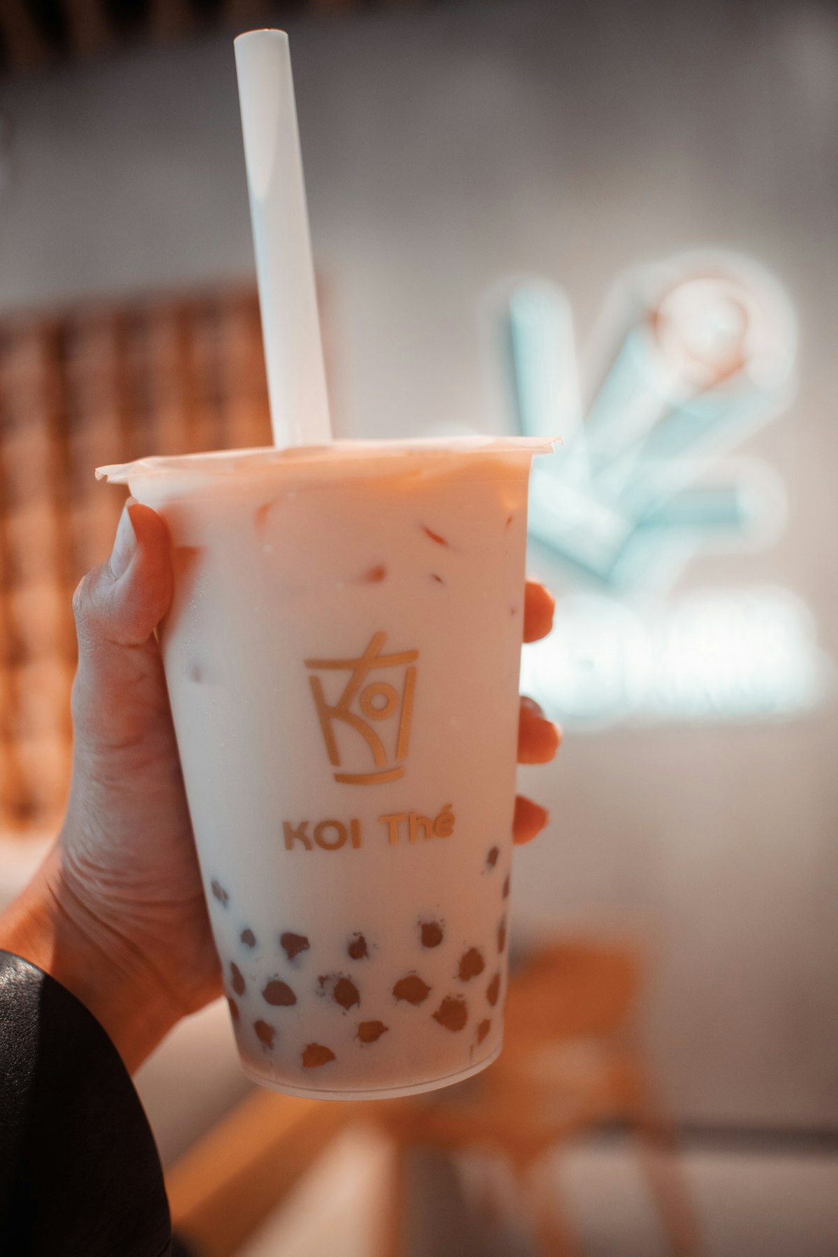 Hand holding a cup of bubble tea with visible tapioca pearls