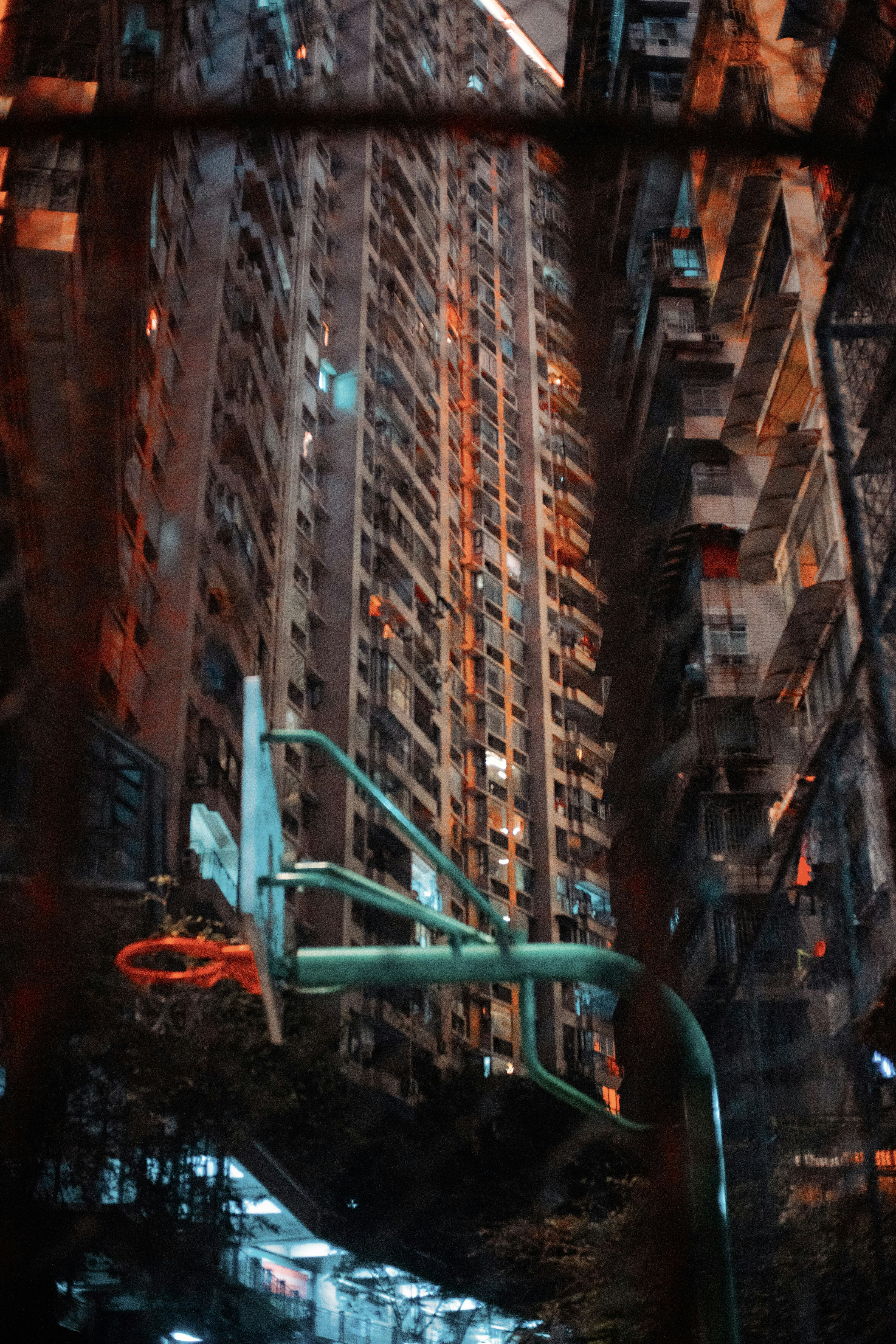 Basketball hoop in front of tall apartment buildings at night