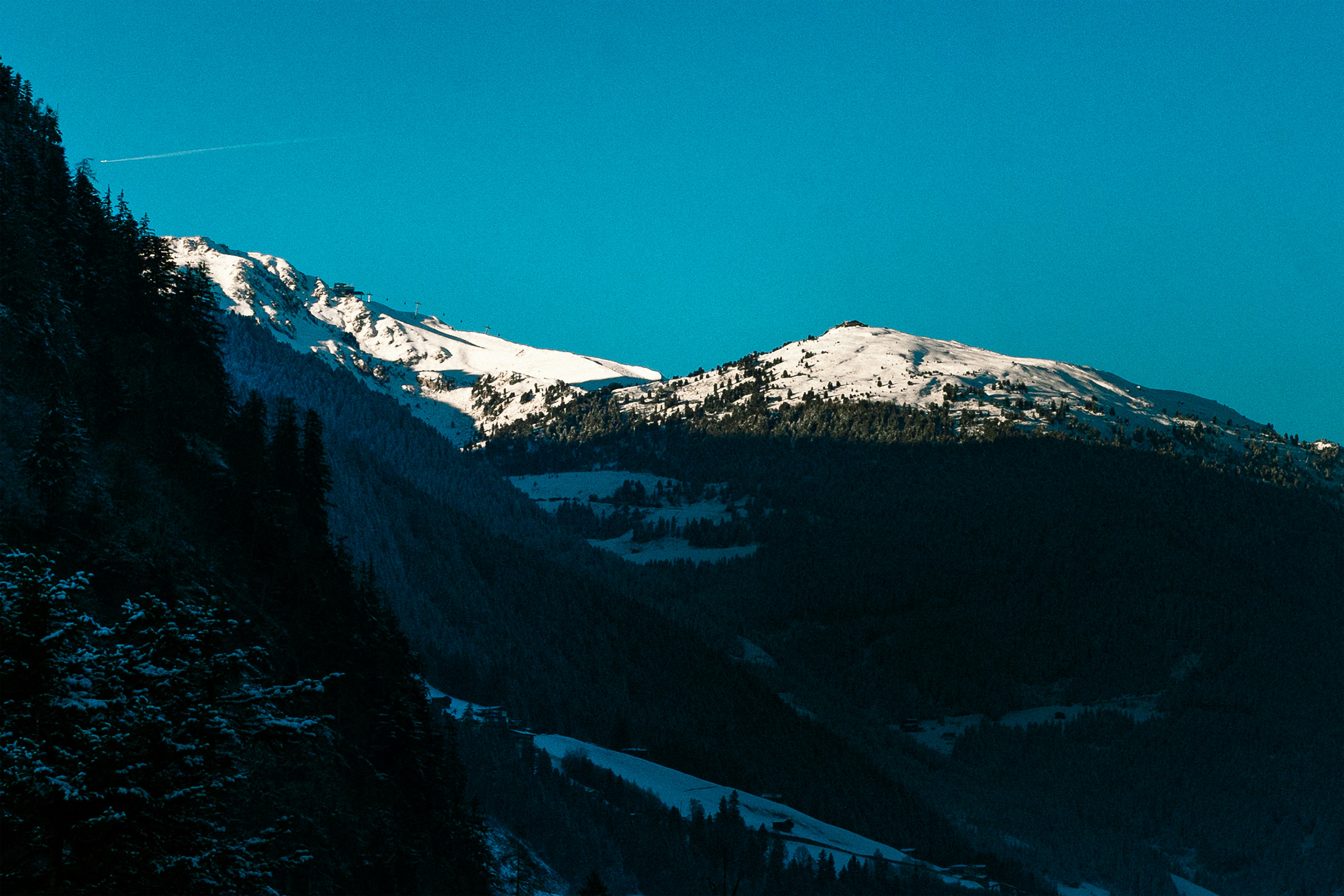 Montanhas cobertas de neve sob um céu azul claro