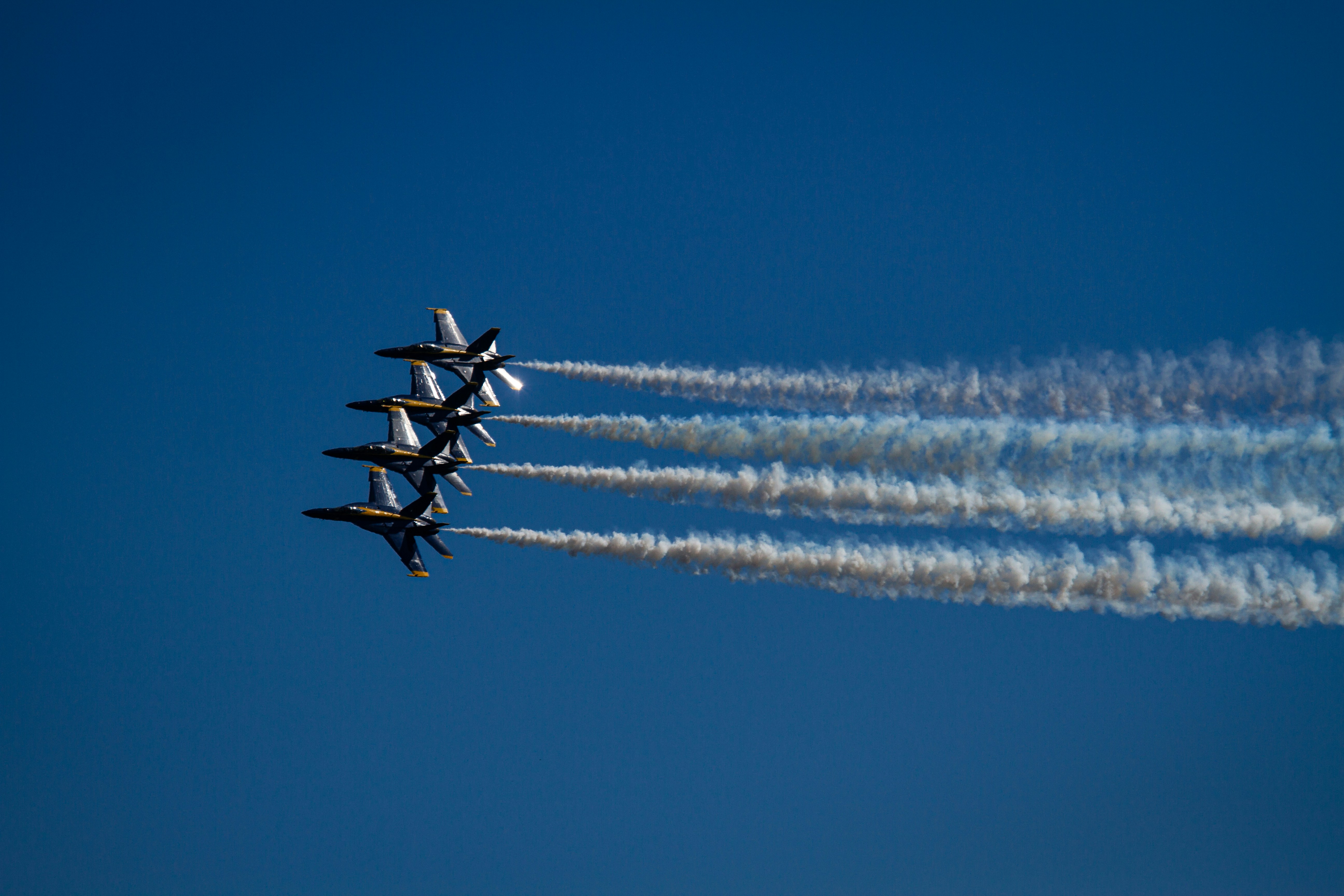 Four fighter jets flying in formation leaving smoke trails