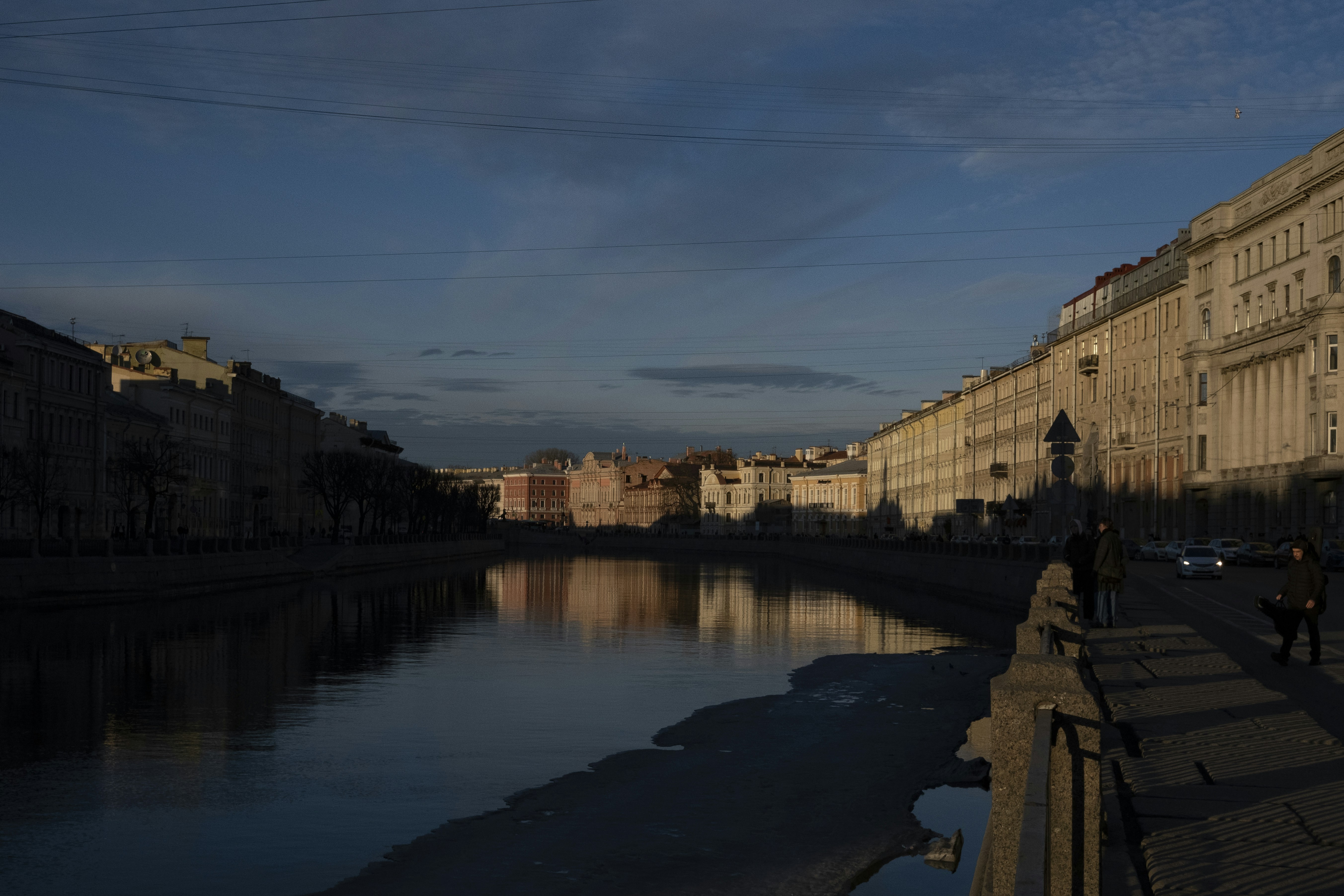Bangunan yang memantulkan sungai di bawah langit senja