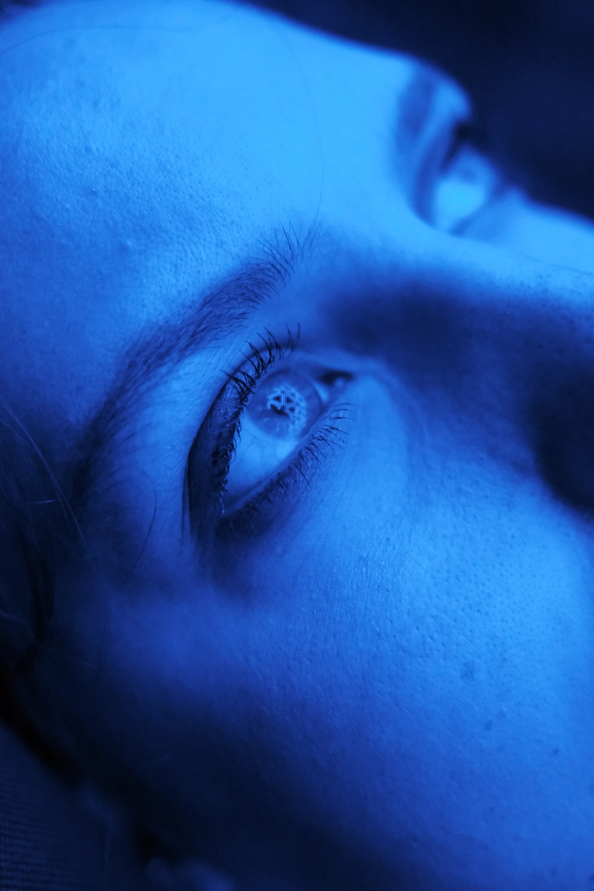 Close up of a person's eye with blue lighting.