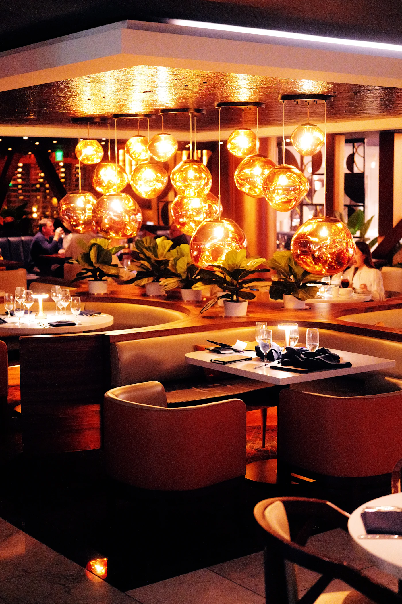 Warmly lit restaurant dining room with set tables