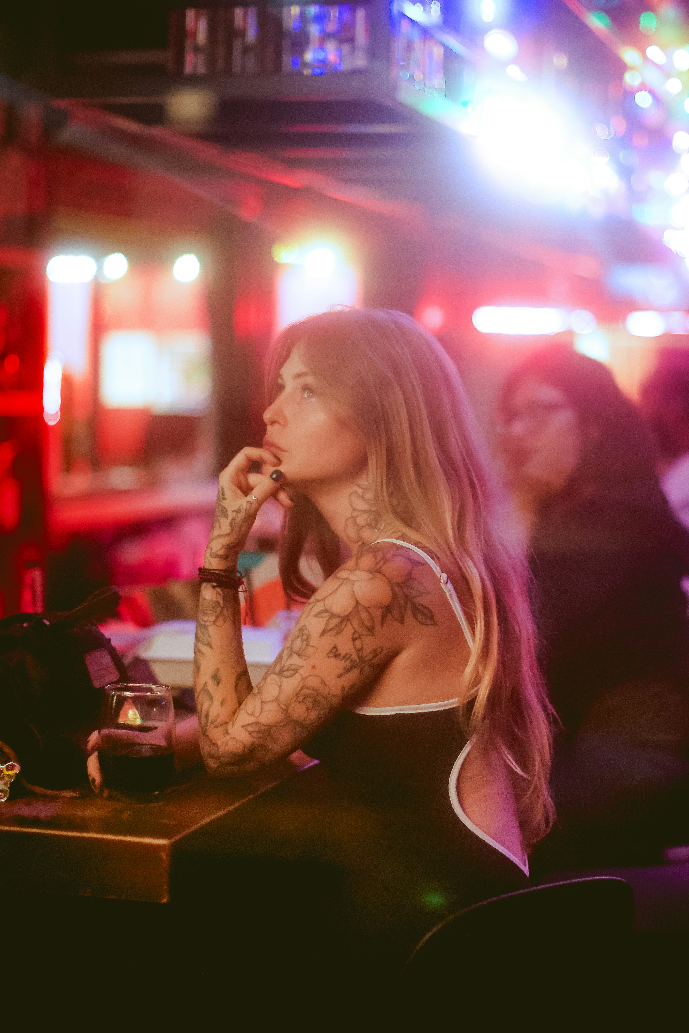 Woman with tattoos sitting at a bar