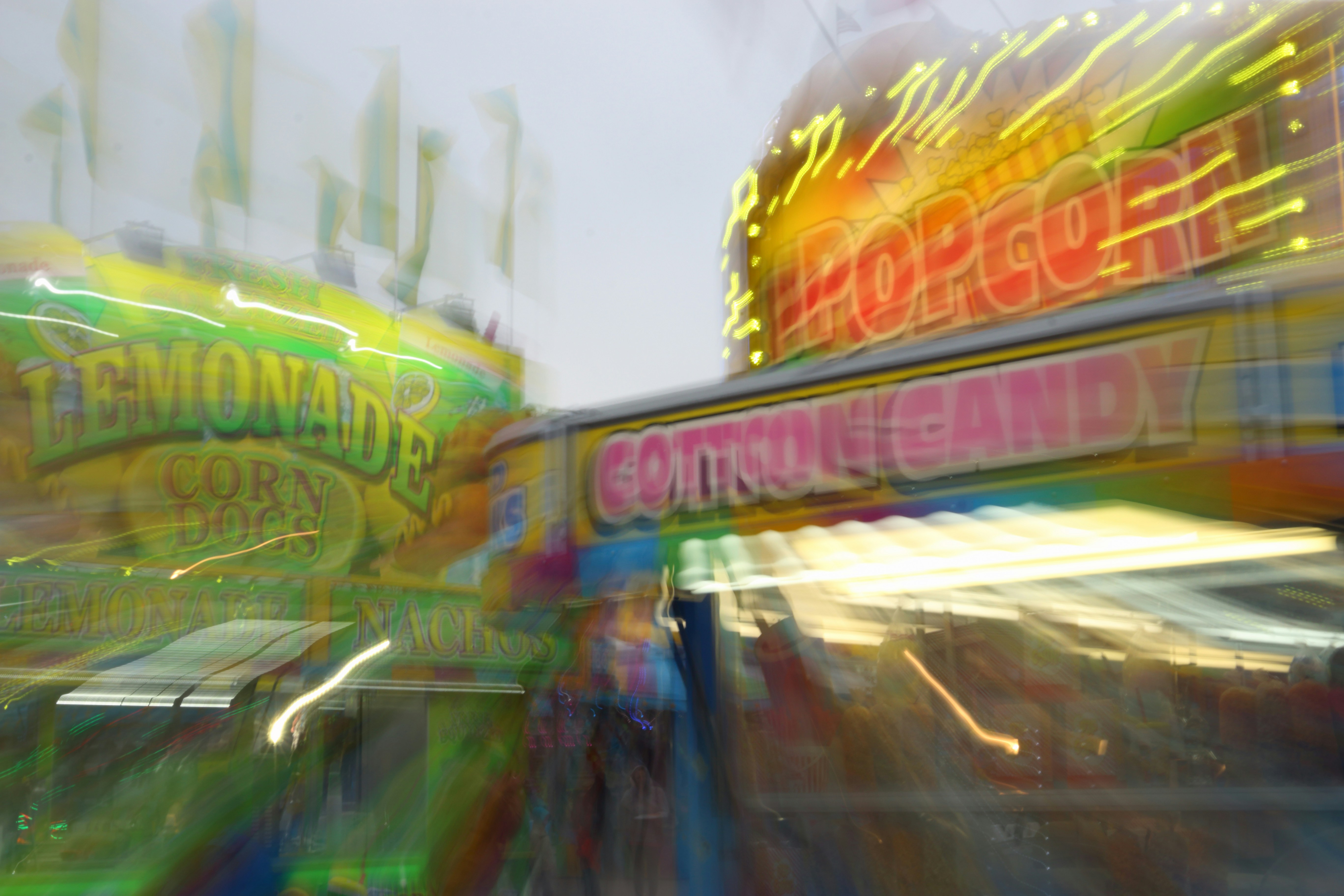 Blurry carnival stands with popcorn and lemonade signs