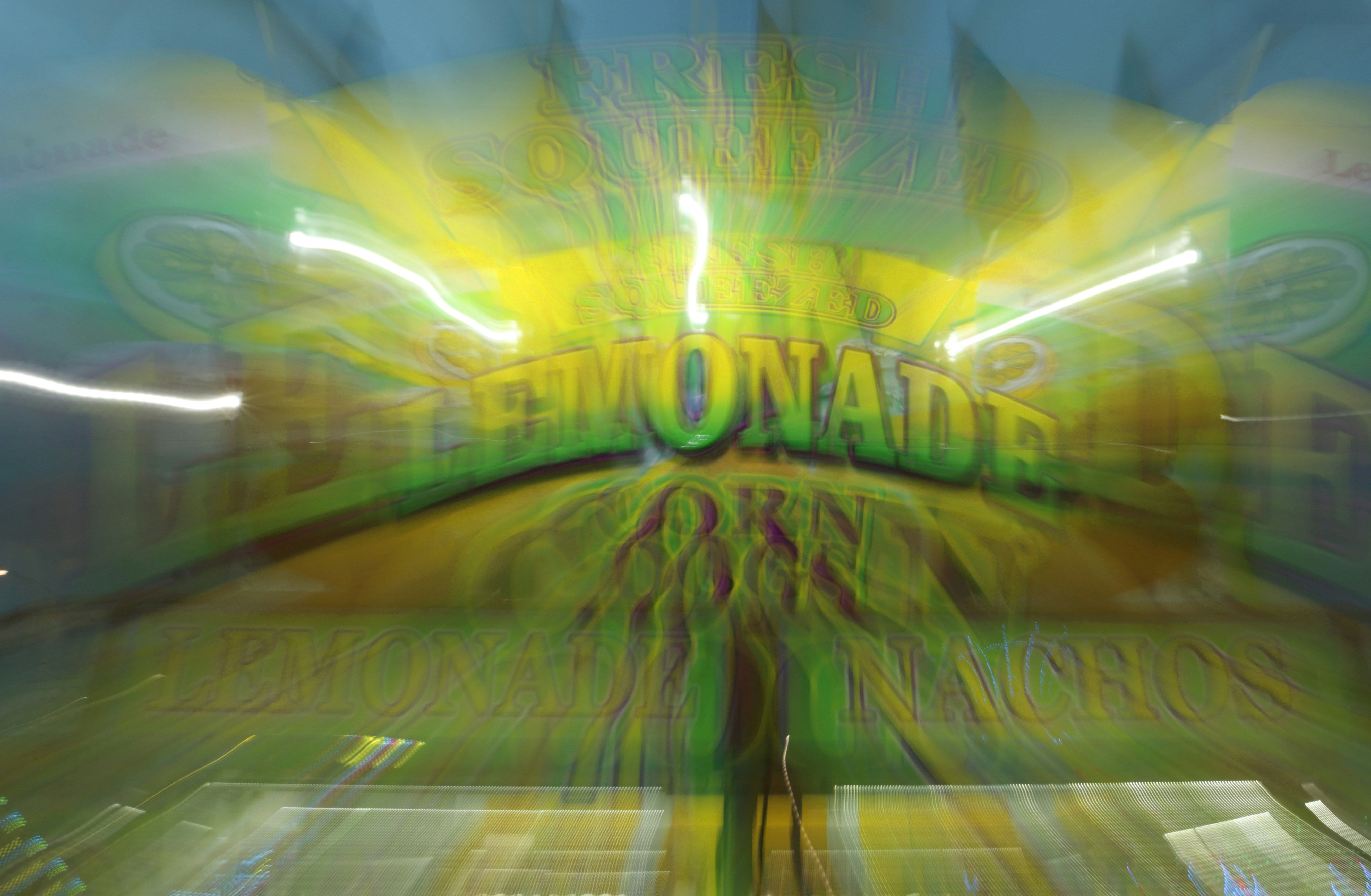 Blurry sign for lemonade with bright yellow and green colors.