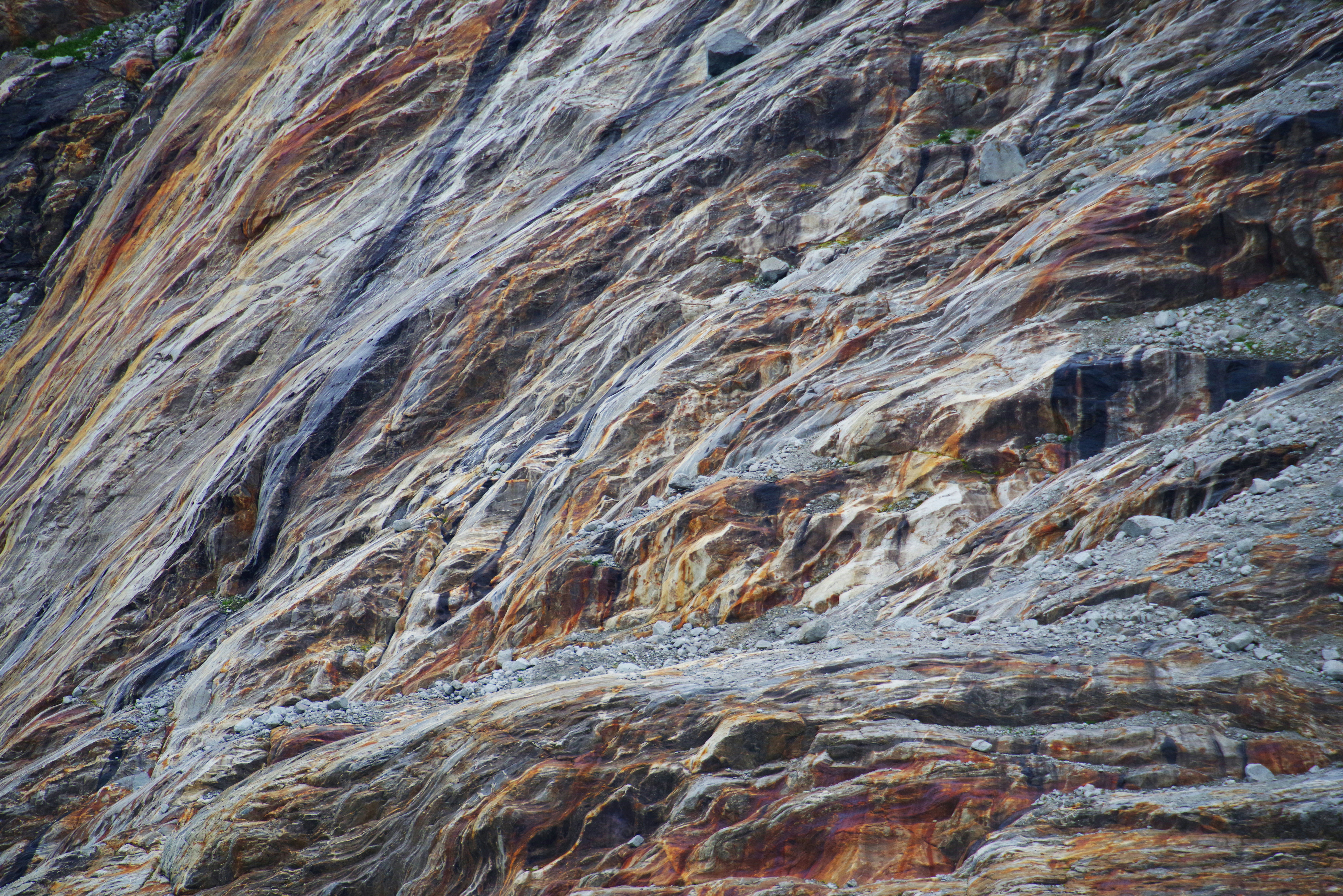 Textured rock face with varied colors and striations.