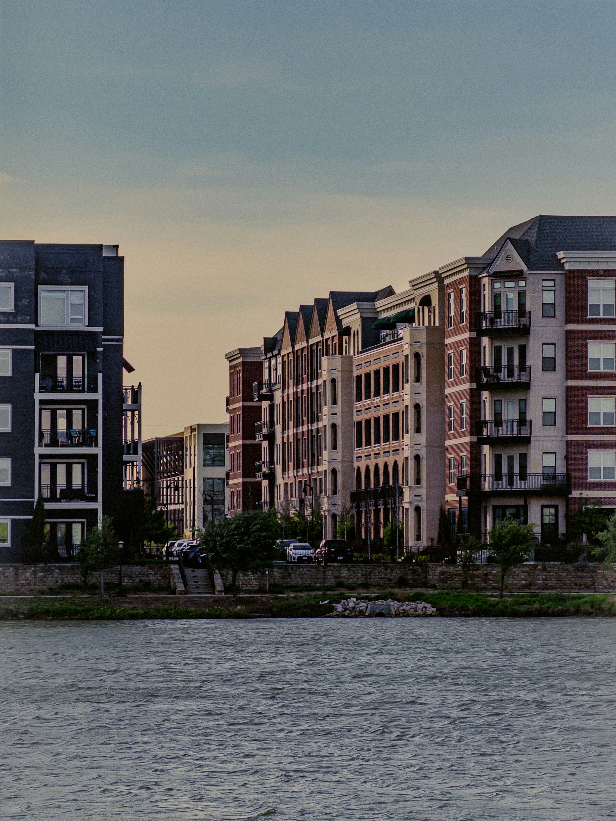 Apartment buildings line the waterfront under a hazy sky