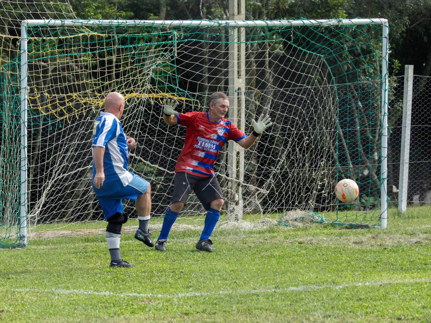 A goalkeeper spreads his arms in front of the goal net as a penalty comes in, with a nine-zone heat map glowing over the goal mouth