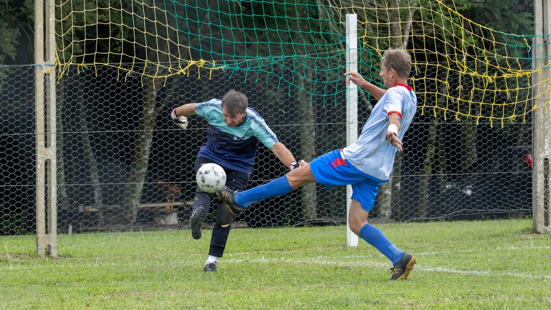 Two boys playing soccer near a goal